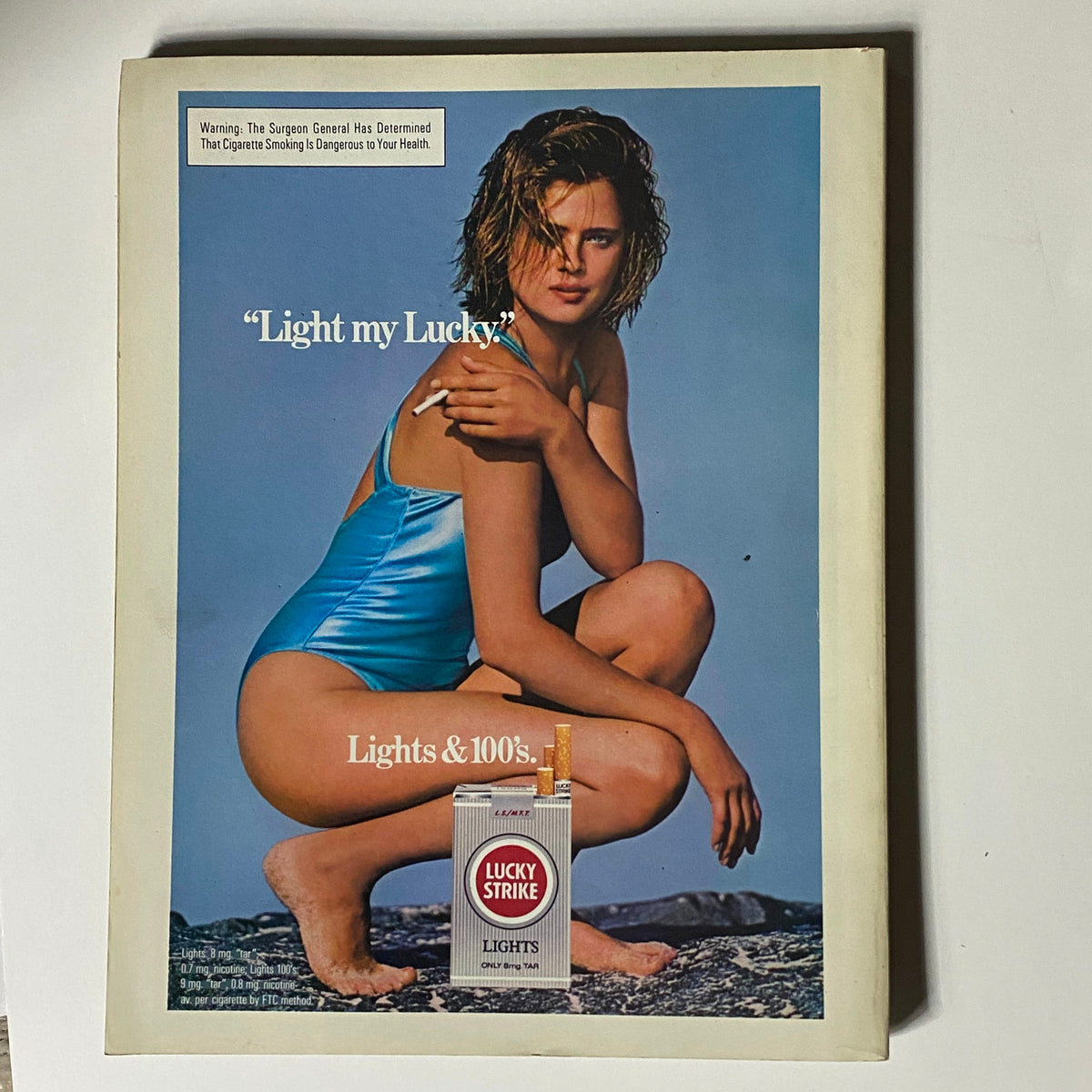Back cover of the Vintage Playboy Magazine October 1985, showcasing a vintage advertisement for Lucky Strike cigarettes with a model in a blue swimsuit.