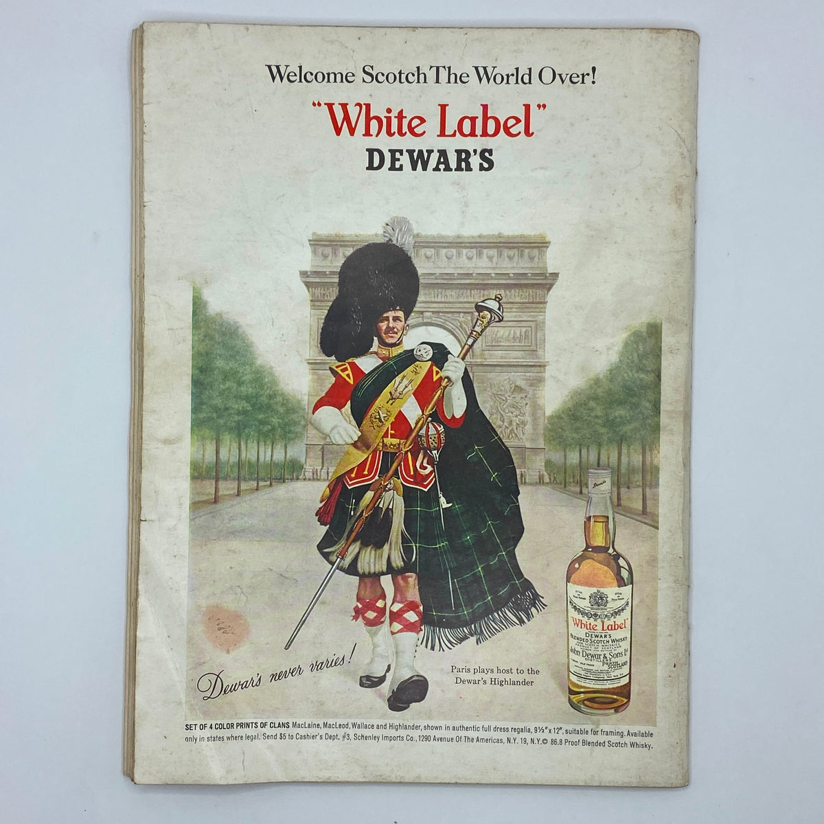 Vintage advertisement for Dewar's White Label Scotch Whisky, with a Scottish soldier in traditional attire against an iconic backdrop.