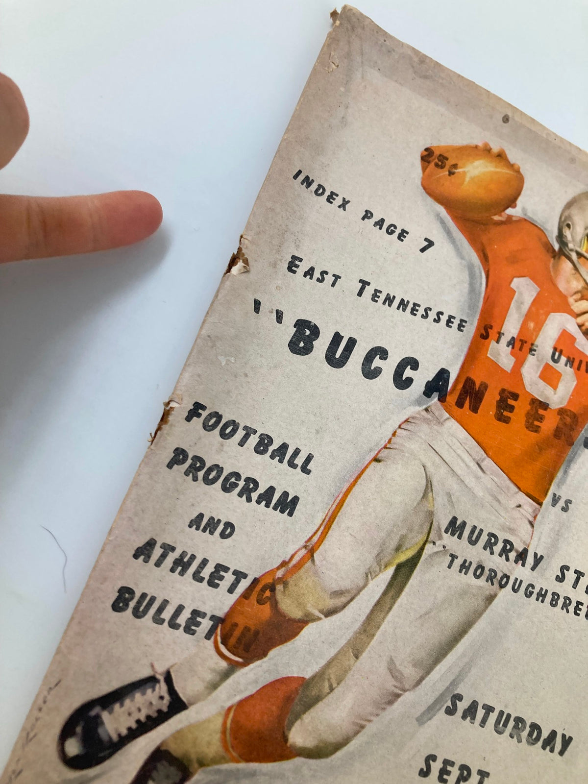 Close-up view of the vintage football program cover from September 21, 1963, highlighting details like the title and teams involved: ETSU Buccaneers vs. Murray State Thoroughbreds.