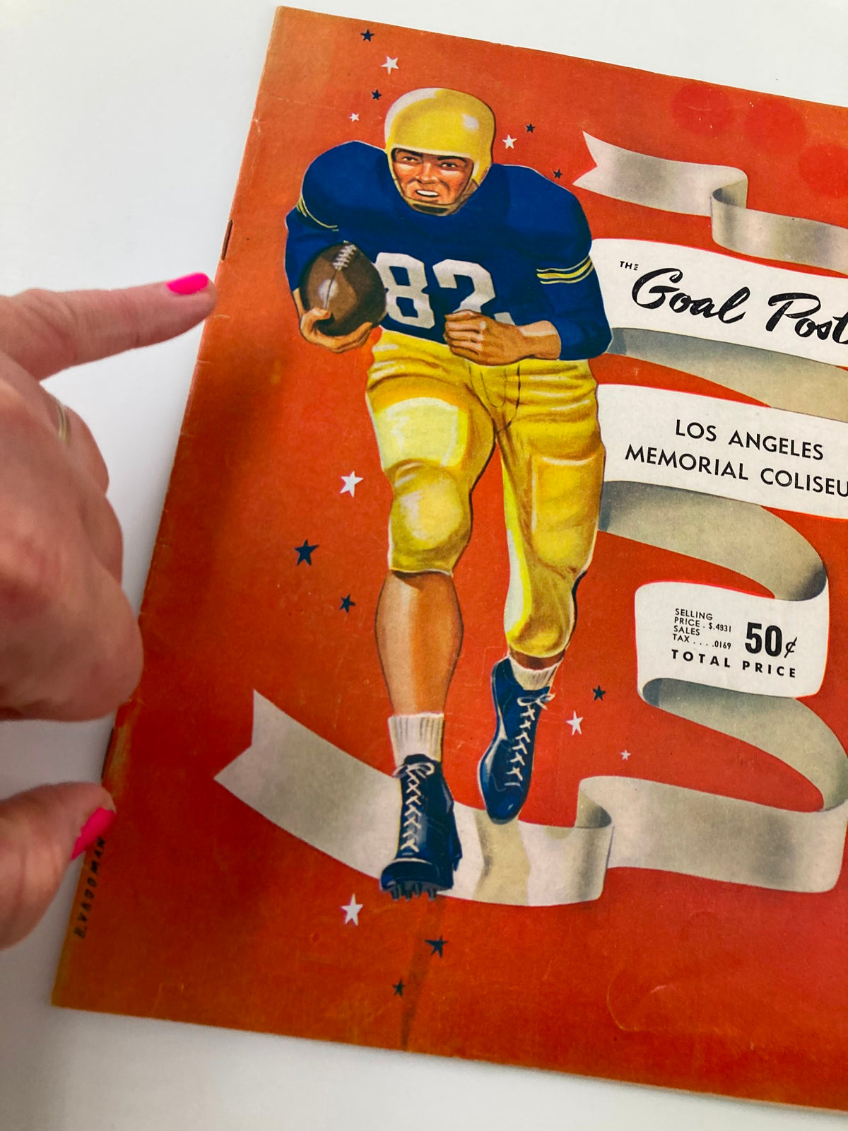 Close-up view of the September 18, 1953 NCAA Football program titled 'The Goal Post', featuring a player in a yellow helmet and blue uniform.