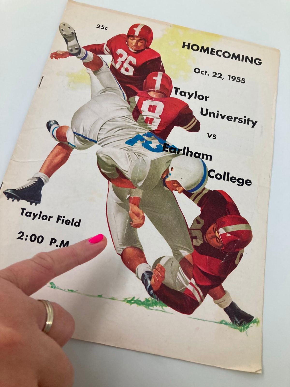 Cover of the vintage football program titled 'VTG October 22 1955 Football Taylor University vs Earlham College Program' showcasing a dynamic football play with players from both teams.