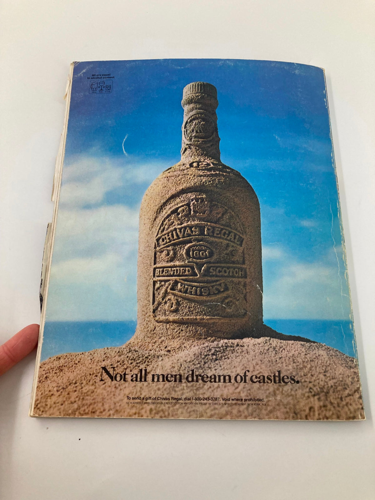 Back cover of the VTG December 31 1985 Air Force vs Texas Bluebonnet Bowl Official Program featuring an artistic sandcastle image and an advertisement for Chivas Regal blended Scotch whisky.