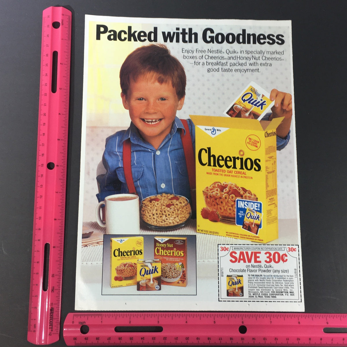 Close-up of the VTG Retro 1987 Nestle Quick Chocolate Flavor Powder Milk Print Ad highlighting a boy with Cheerios, emphasizing the savings coupon details.