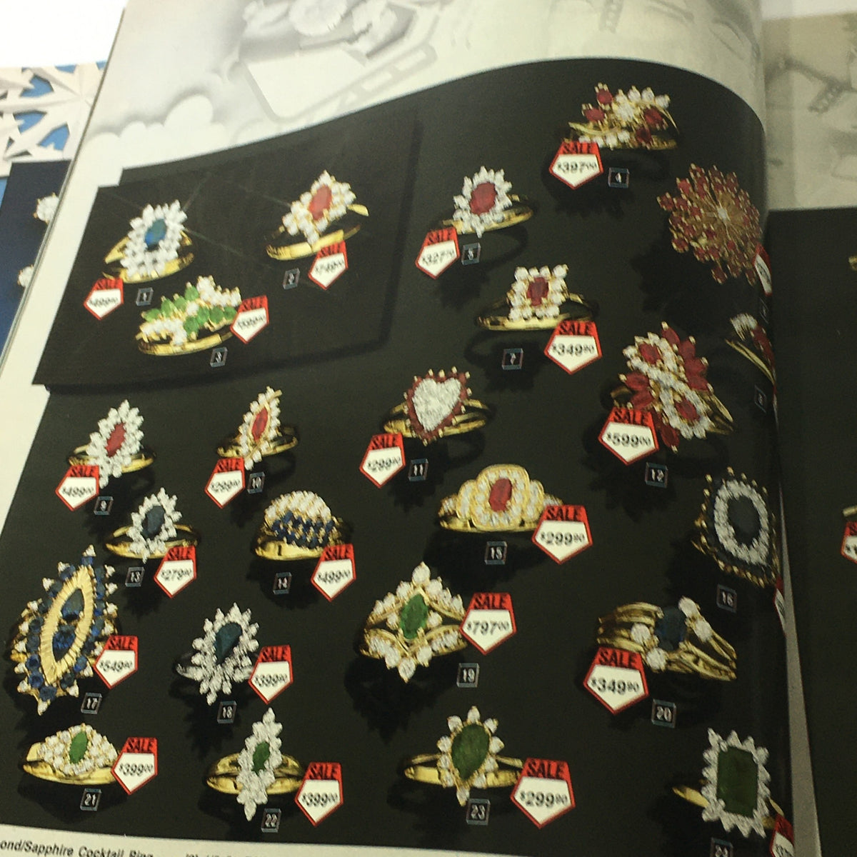 VTG Service Merchandise Showroom 1983 Christmas Sale Price Guide Catalog highlighting colorful cocktail rings, with vivid gemstones and discounted prices.
