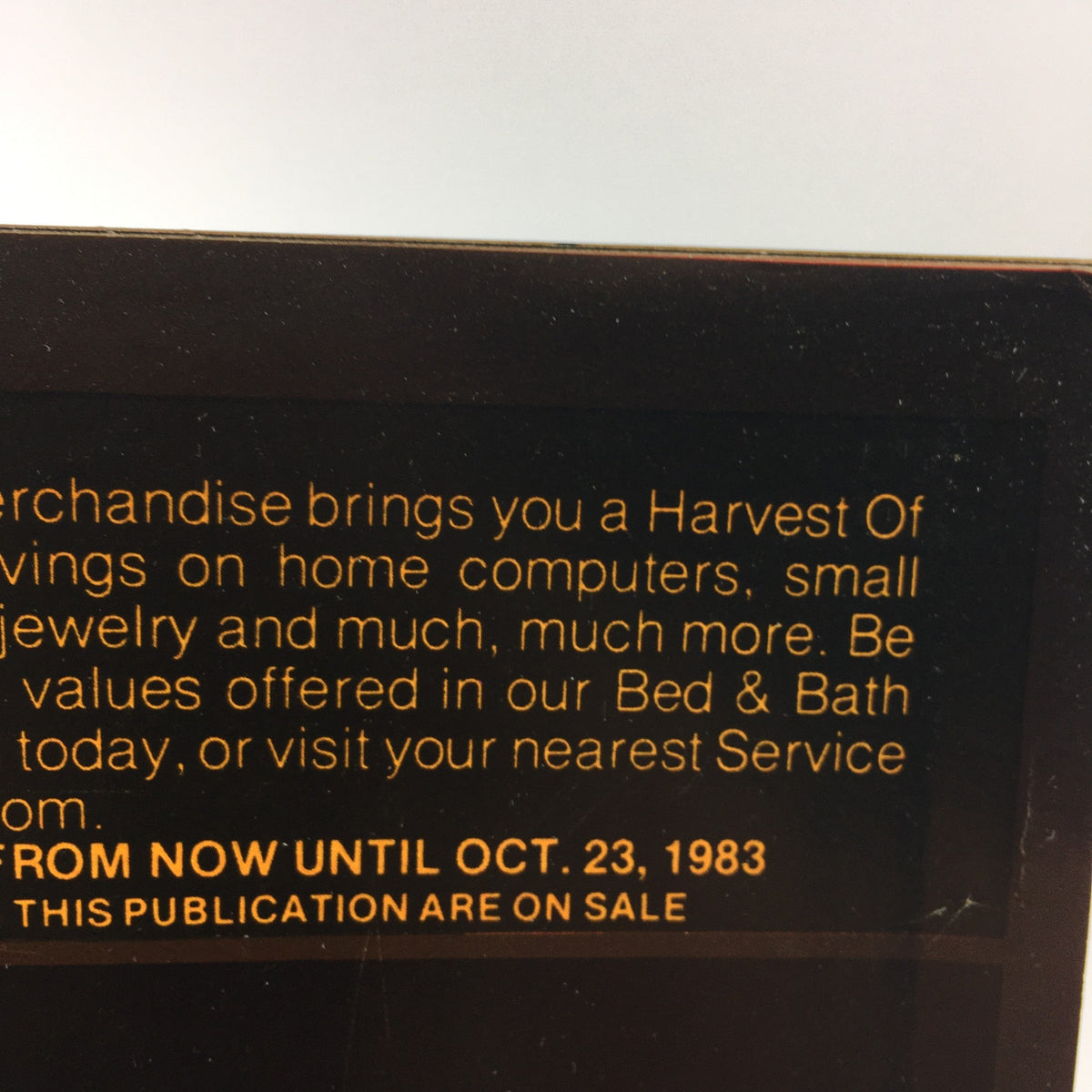 Close-up of the 1983 Service Merchandise Catalog header detailing the 'Harvest of Values' promotion with information on savings for home computers and jewelry, featuring the promotional dates in gold text.