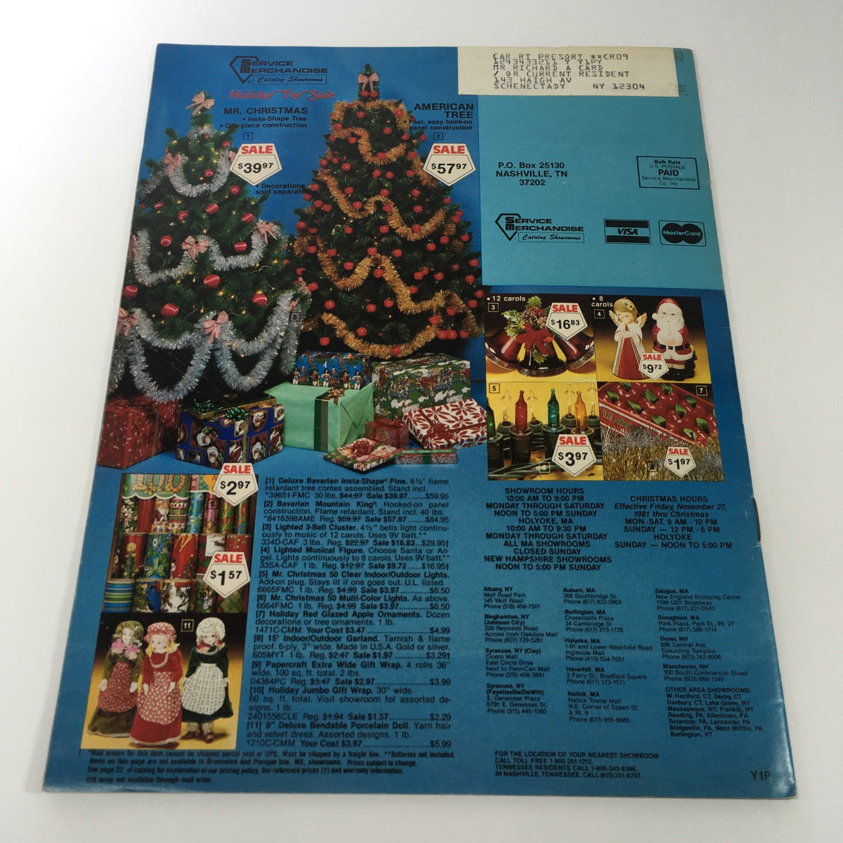 Vintage 1981 Service Merchandise Catalog Holiday Toy Sale with sales prices and festive decorations, including Christmas trees and dolls.