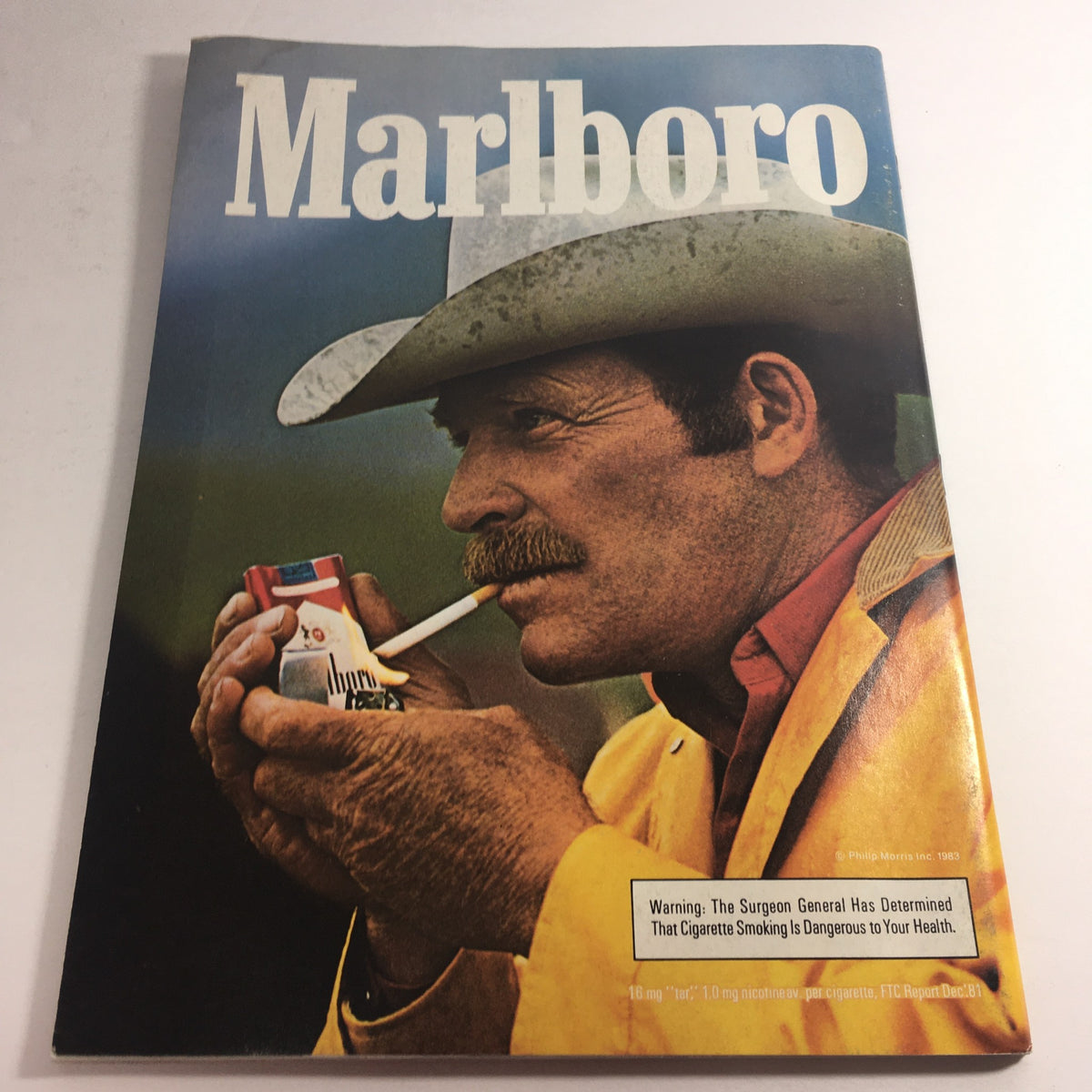 Cover of the 1983 Marlboro magazine featuring a cowboy holding a cigarette, highlighting the advertising style and cultural elements of the era.