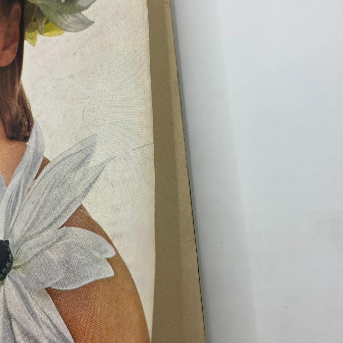 Close-up view of Vogue Magazine cover from March 1, 1964, featuring a model adorned with flowers, emphasizing 60s fashion style and photography by Bert Stern.