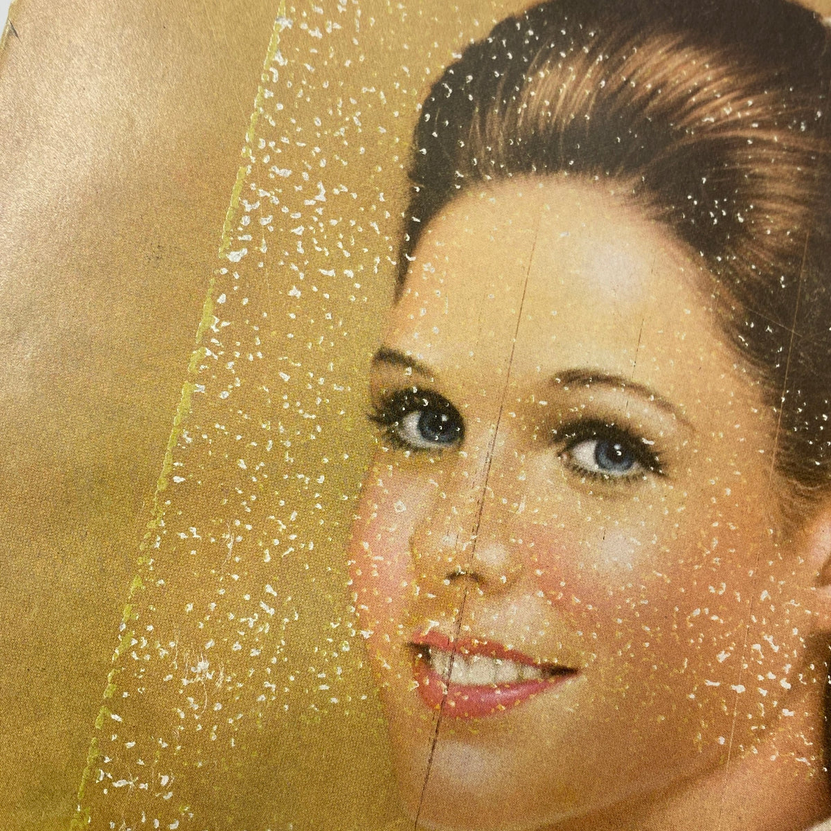 Close-up of a model's face from an advertisement in VTG Vogue Magazine December 1971, showcasing bridal beauty and hair styling trends of the time.