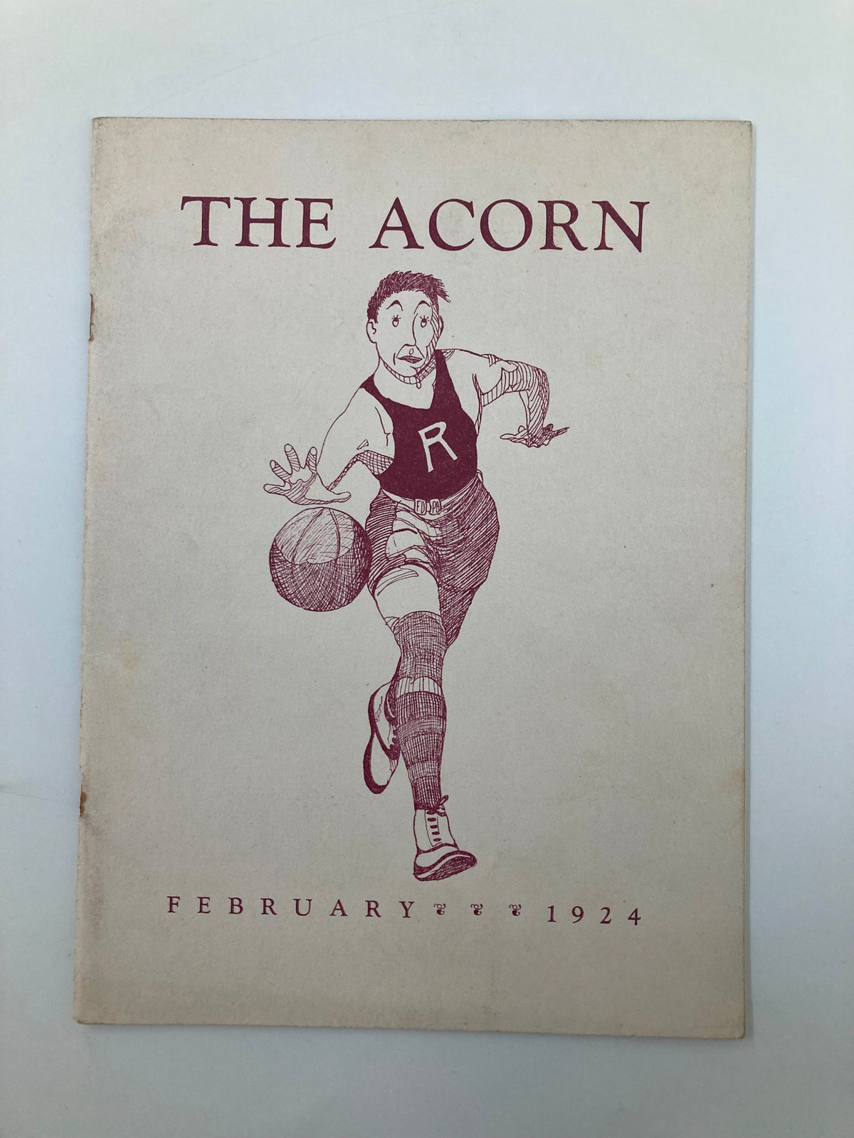 Cover page of February 1924 The Acorn featuring a student athlete from Roanoke High School, depicting a vintage illustration with basketball.