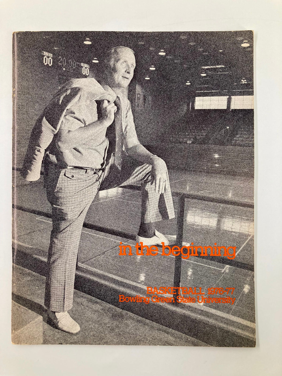 Cover of the 1976-1977 Bowling Green State University Basketball Schedule Program featuring a man in a suit with a tie and sports coat, posed in a basketball arena. This vintage magazine is a historic representation of college basketball.