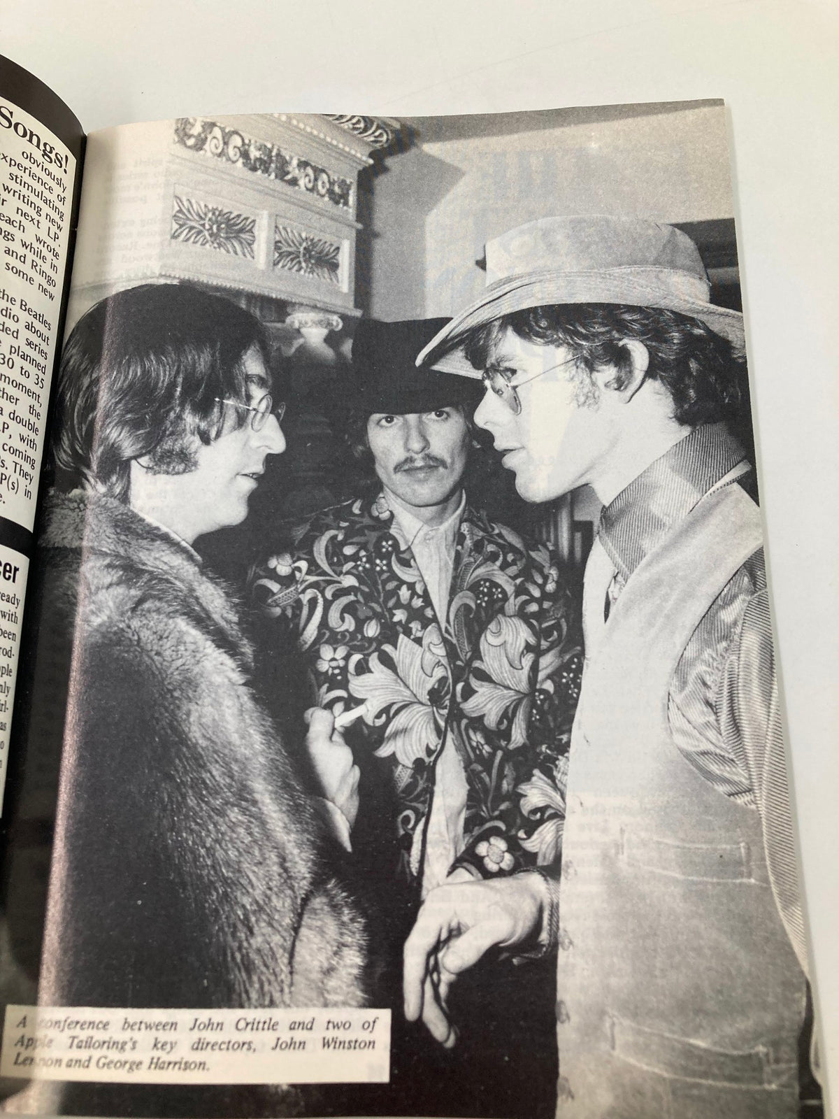 John Lennon, George Harrison, and a director at a conference regarding Apple Tailoring, highlighted in The Beatles Book Monthly Magazine May 1988 No. 145.