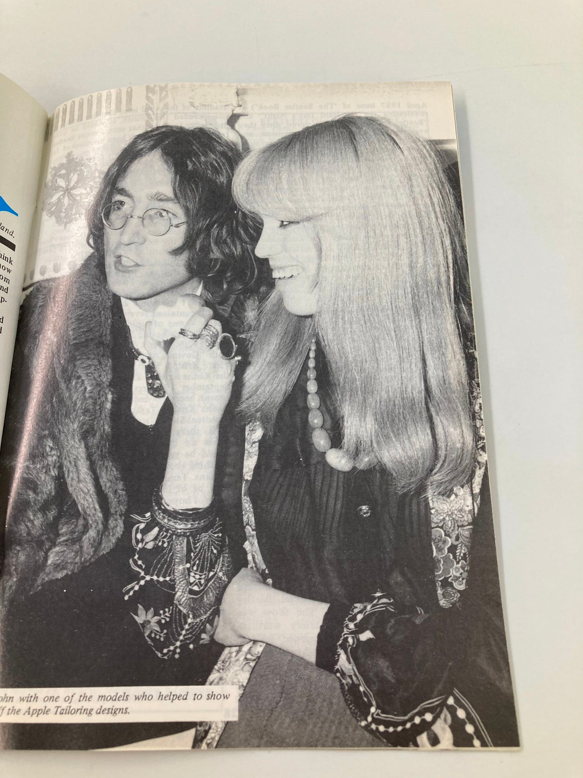 Image from The Beatles Book Monthly Magazine May 1988 No. 145, featuring John Lennon with a model, showcasing 1980s fashion and pop culture. This article details Lennon’s influence in the music industry and his connections during the time.