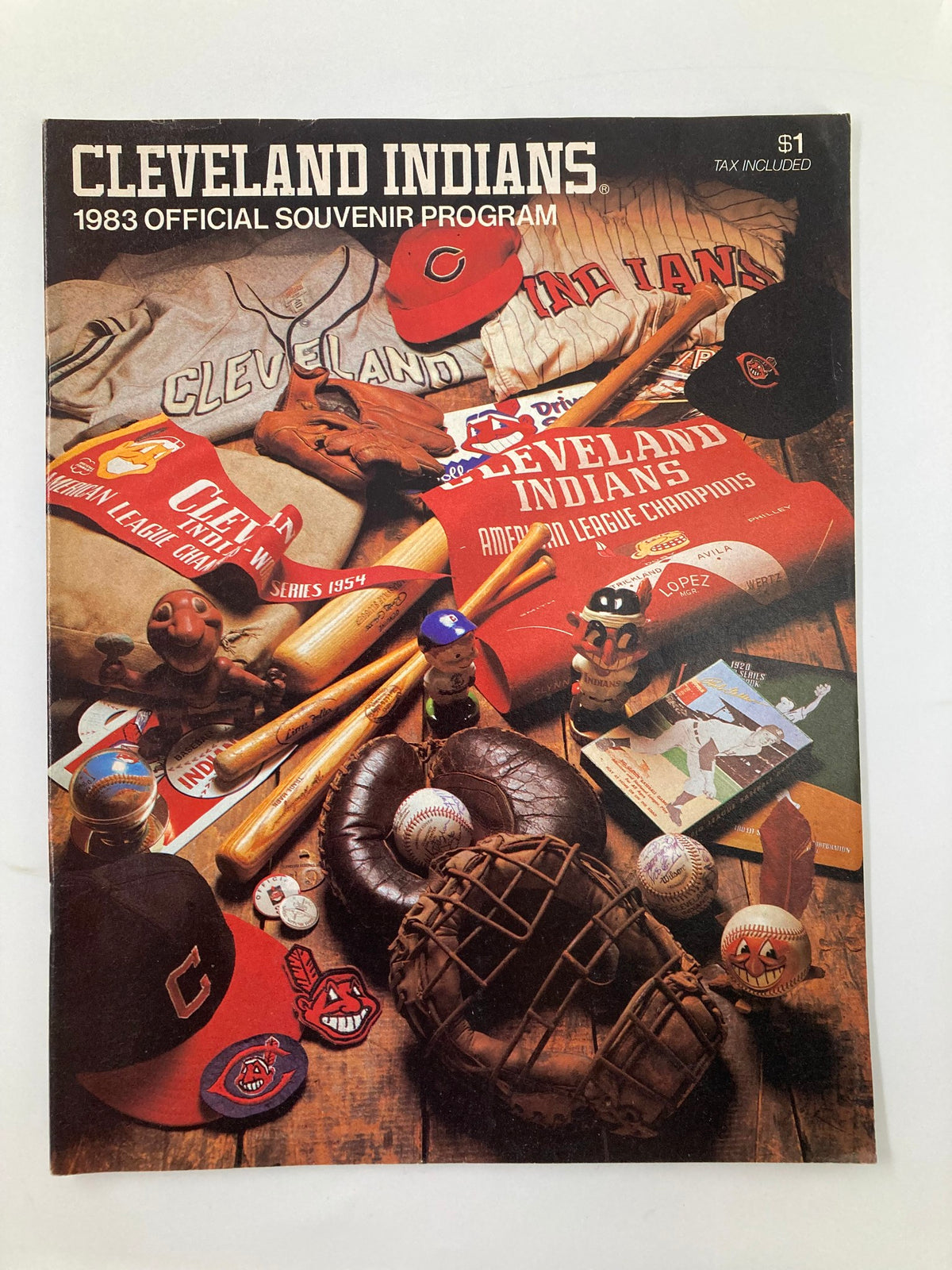 1983 MLB Cleveland Indians vs Milwaukee Brewers Official Souvenir Program displayed with vintage baseball memorabilia including caps, jerseys, gloves, and baseballs, capturing nostalgia from the game.