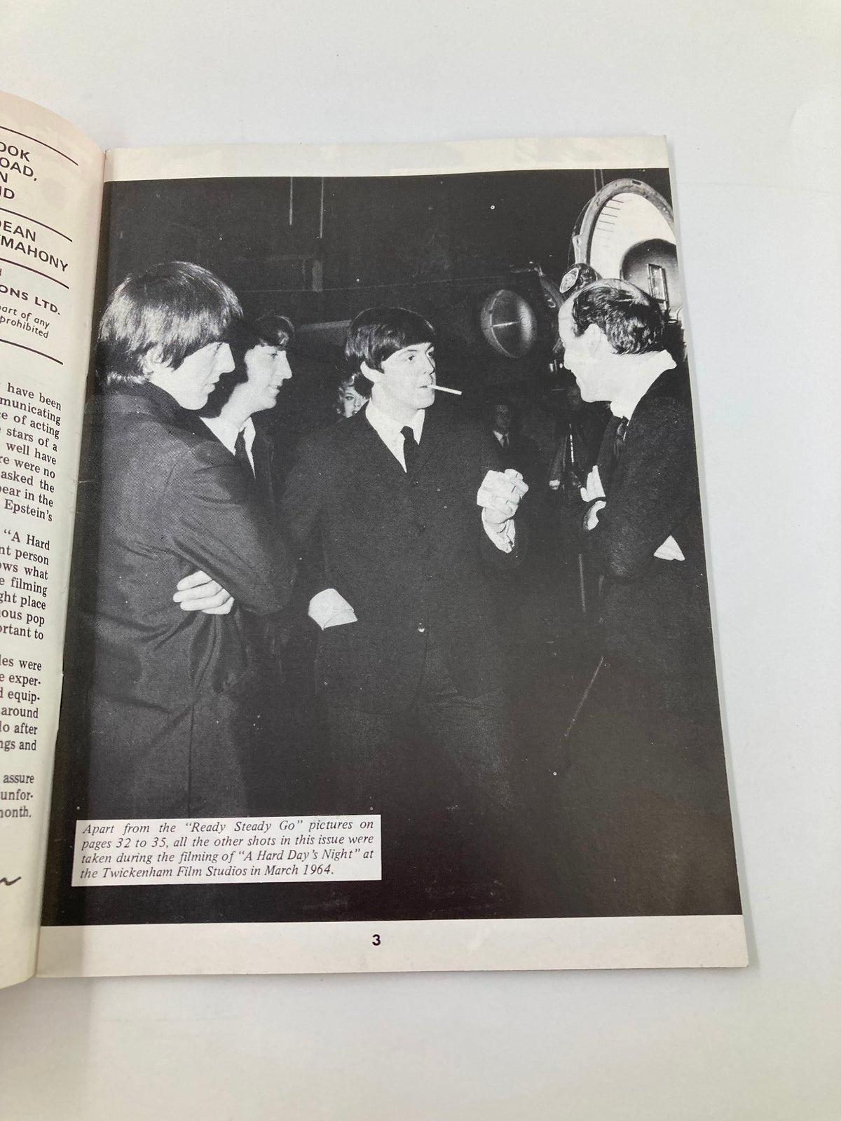 A vintage black and white photo in The Beatles Book Monthly Magazine April 1984, Issue #96, capturing The Beatles interacting during the filming of 'A Hard Day's Night'.
