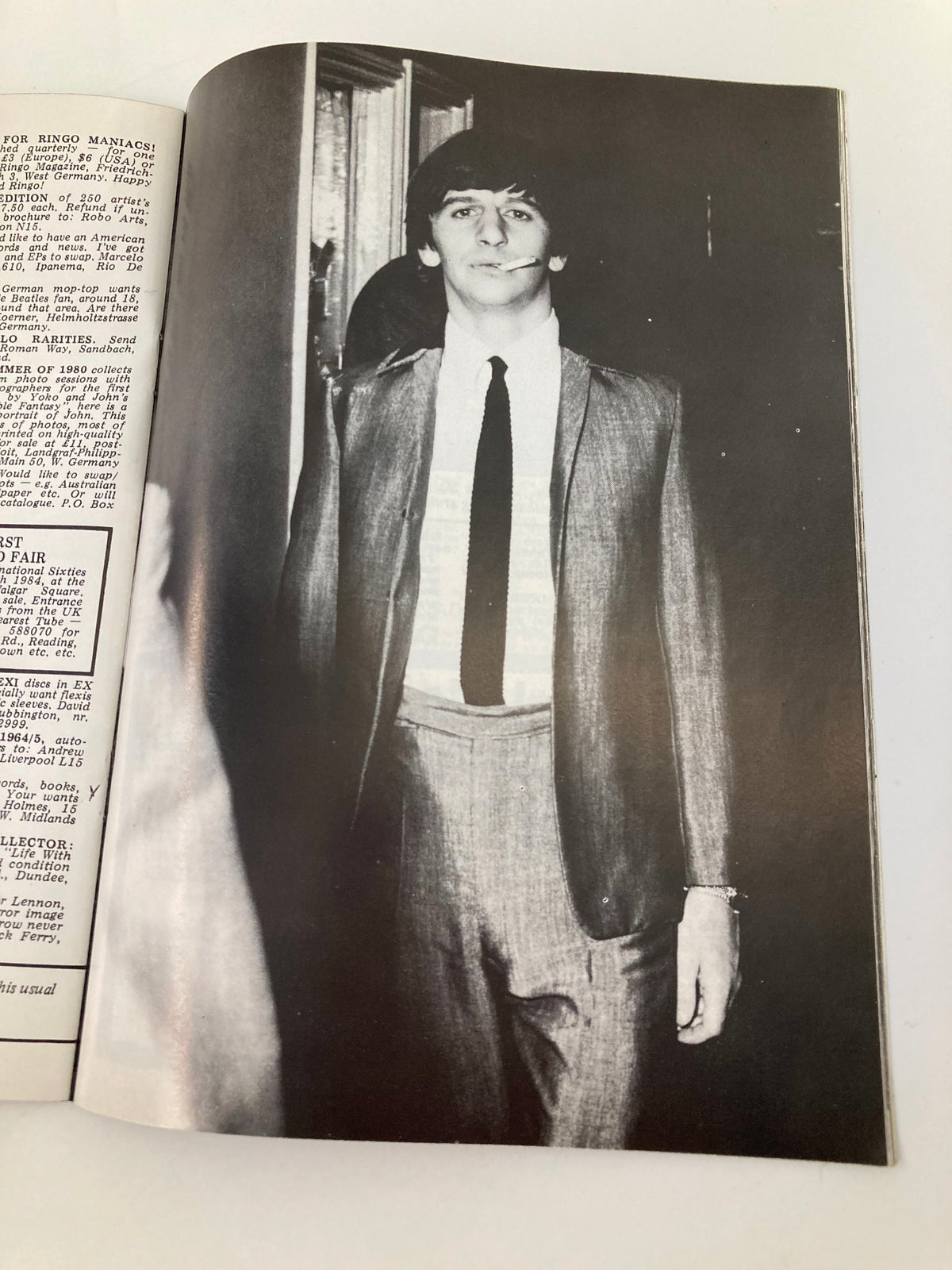 Black and white image of a dressed-up Ringo Starr from The Beatles, captured in a formal suit with a cigarette in hand. This photograph is featured in The Beatles Book Monthly Magazine, April 1984, Issue #96.