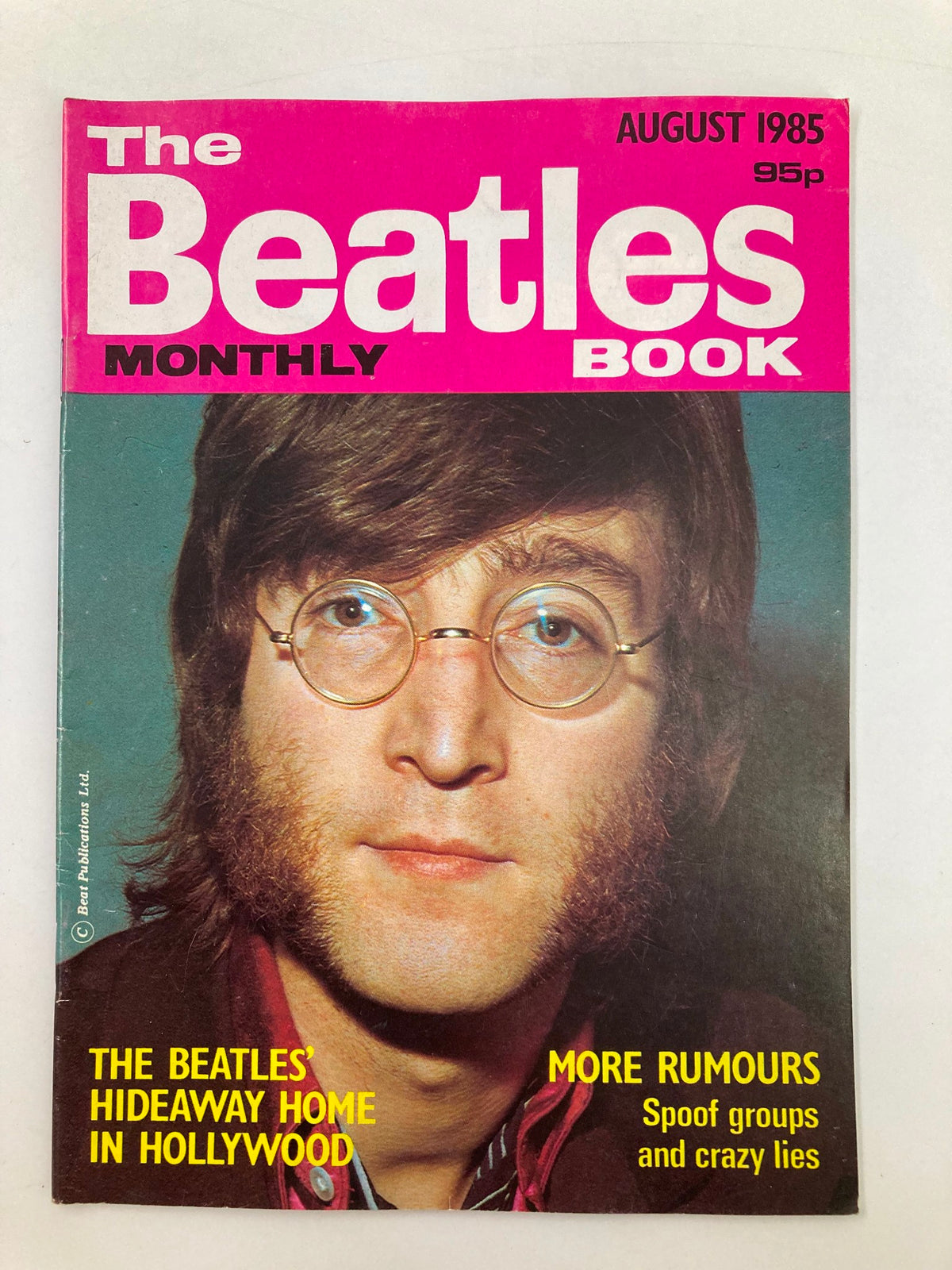 The Beatles Book Monthly Magazine August 1985 Issue #112 featuring John Lennon on the cover with a vibrant pink header. The magazine highlights The Beatles' influence in music and features articles from that era.