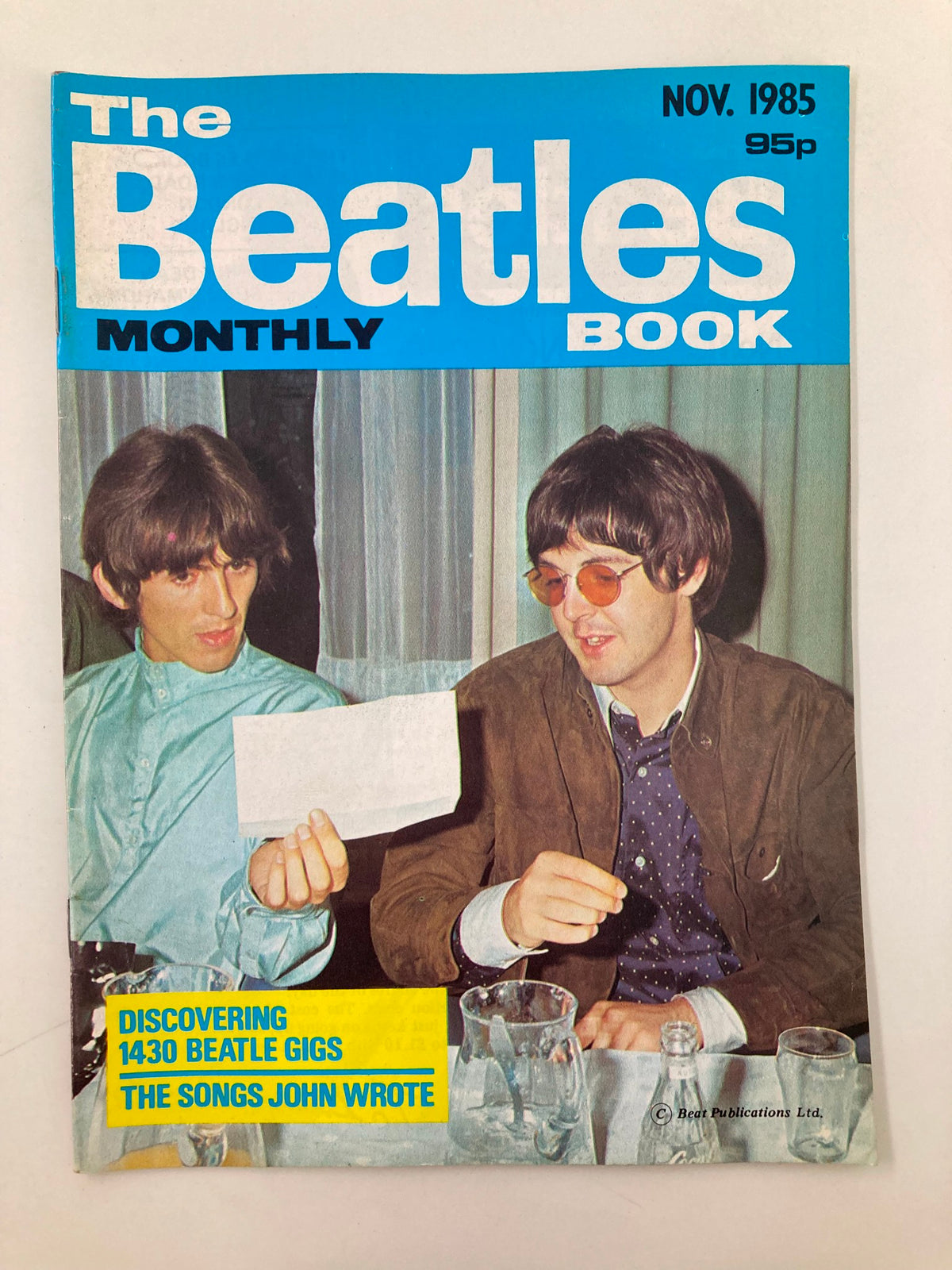 The Beatles Book Monthly Magazine November 1985 cover featuring two musicians discussing with a note in hand, highlighting the theme 'The Songs John Wrote'.