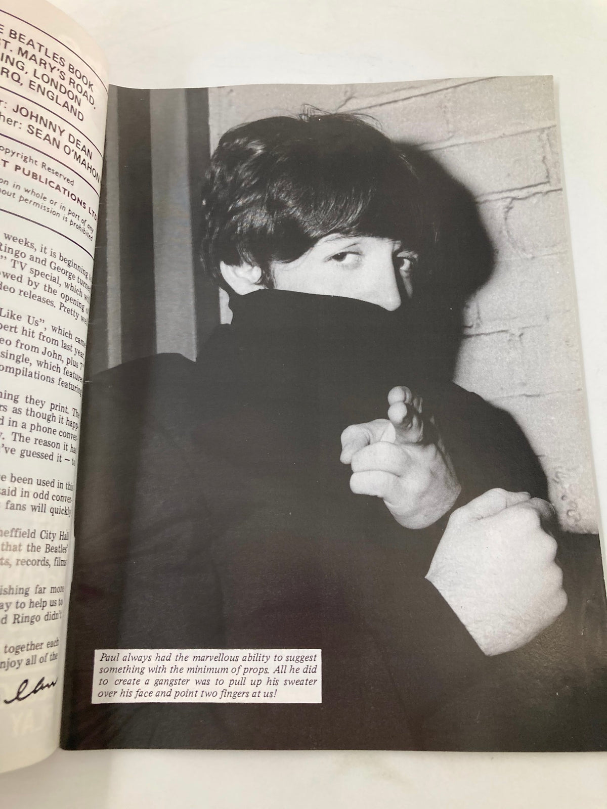 Black and white photo of a band member peeking out from under a sweater in The Beatles Book Monthly Magazine, December 1985 Issue #116, emphasizing his playful character.