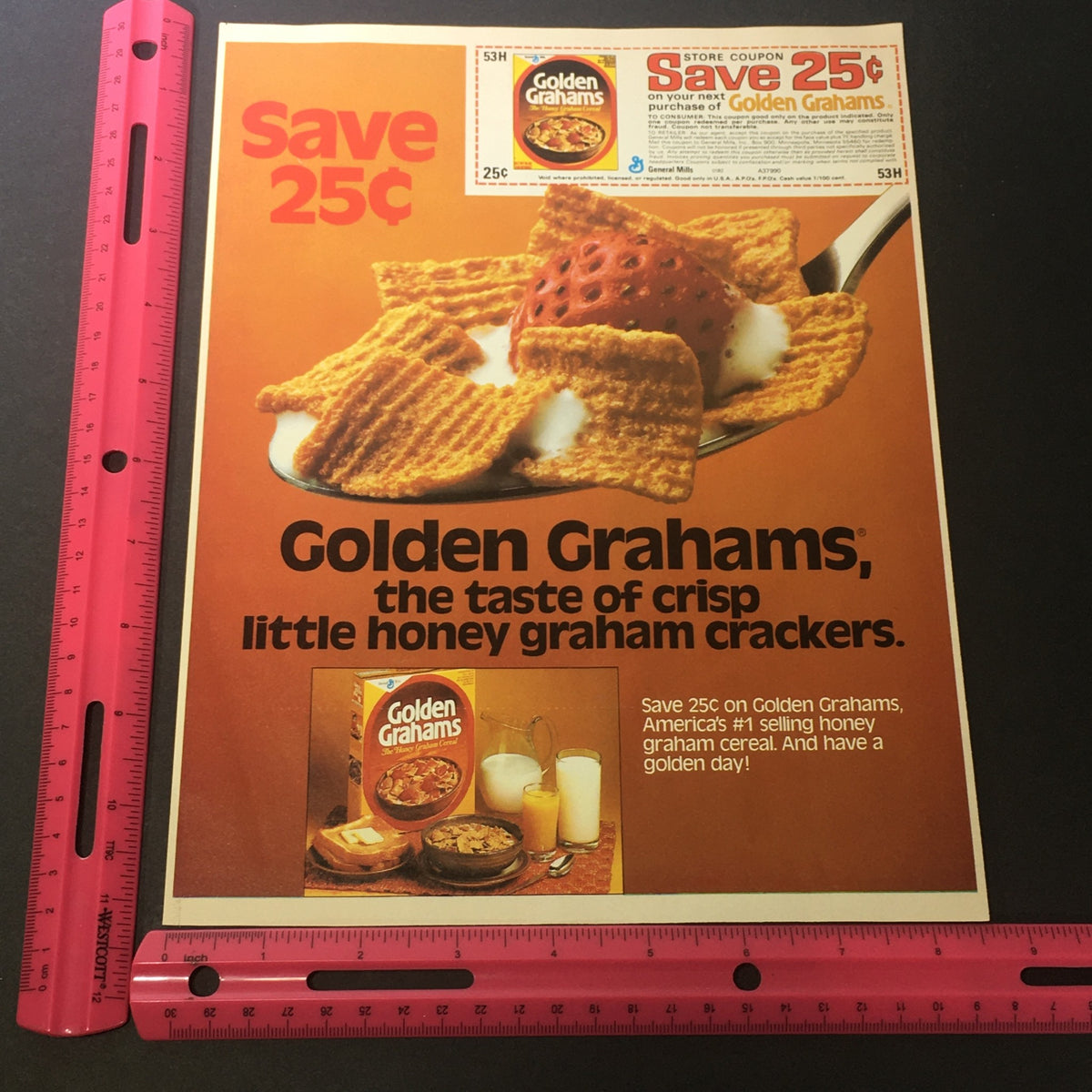 VTG Retro 1982 General Mill's Golden Graham Honey Graham Crackers advertisement featuring a coupon to save 25 cents. The image shows the product, a bowl of Golden Grahams cereal with milk, highlighting the taste of crisp little honey graham crackers.