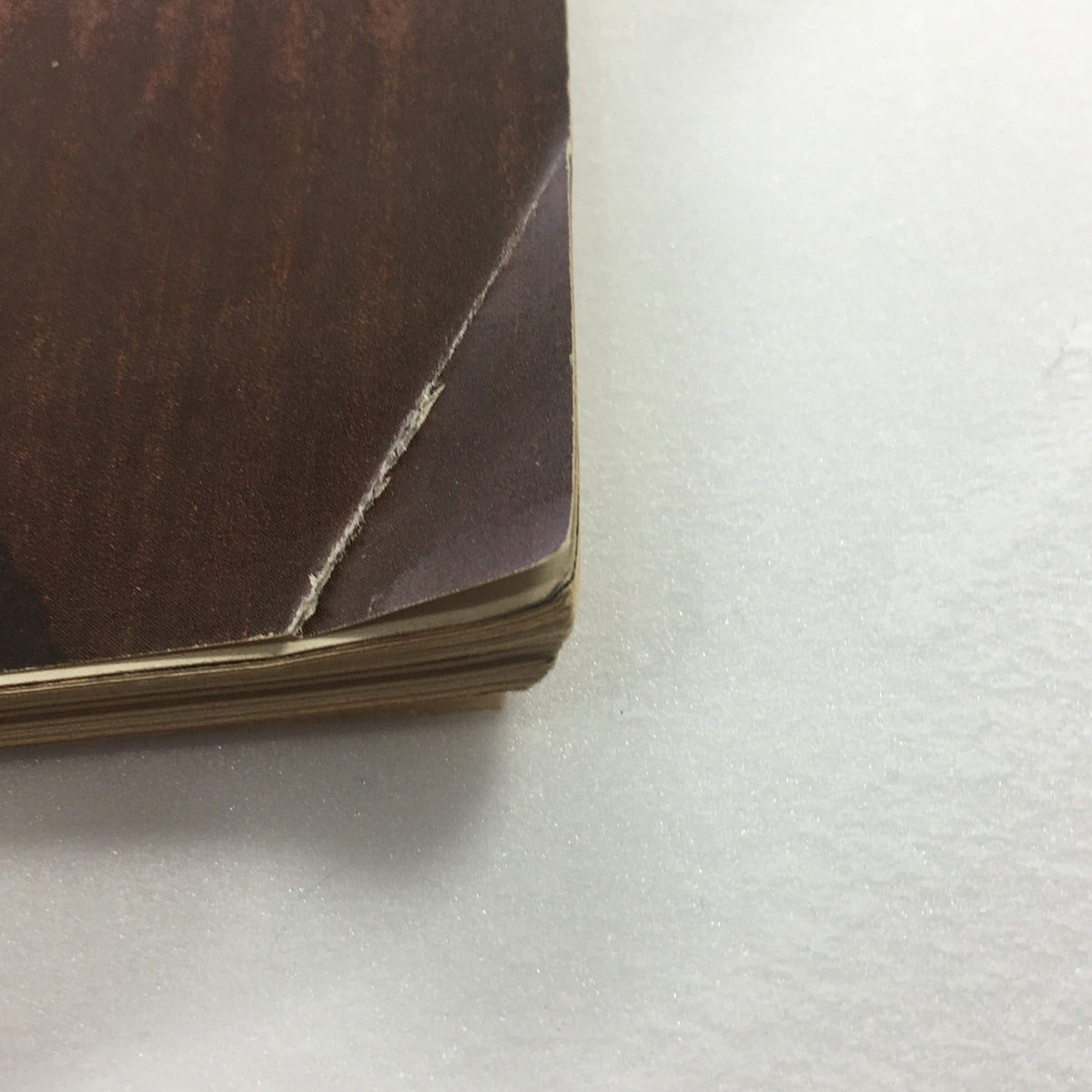 Close-up view of the worn corner of the vintage Playboy Magazine May 1962 Vol. 9 #5, showcasing minor damage and age wear.