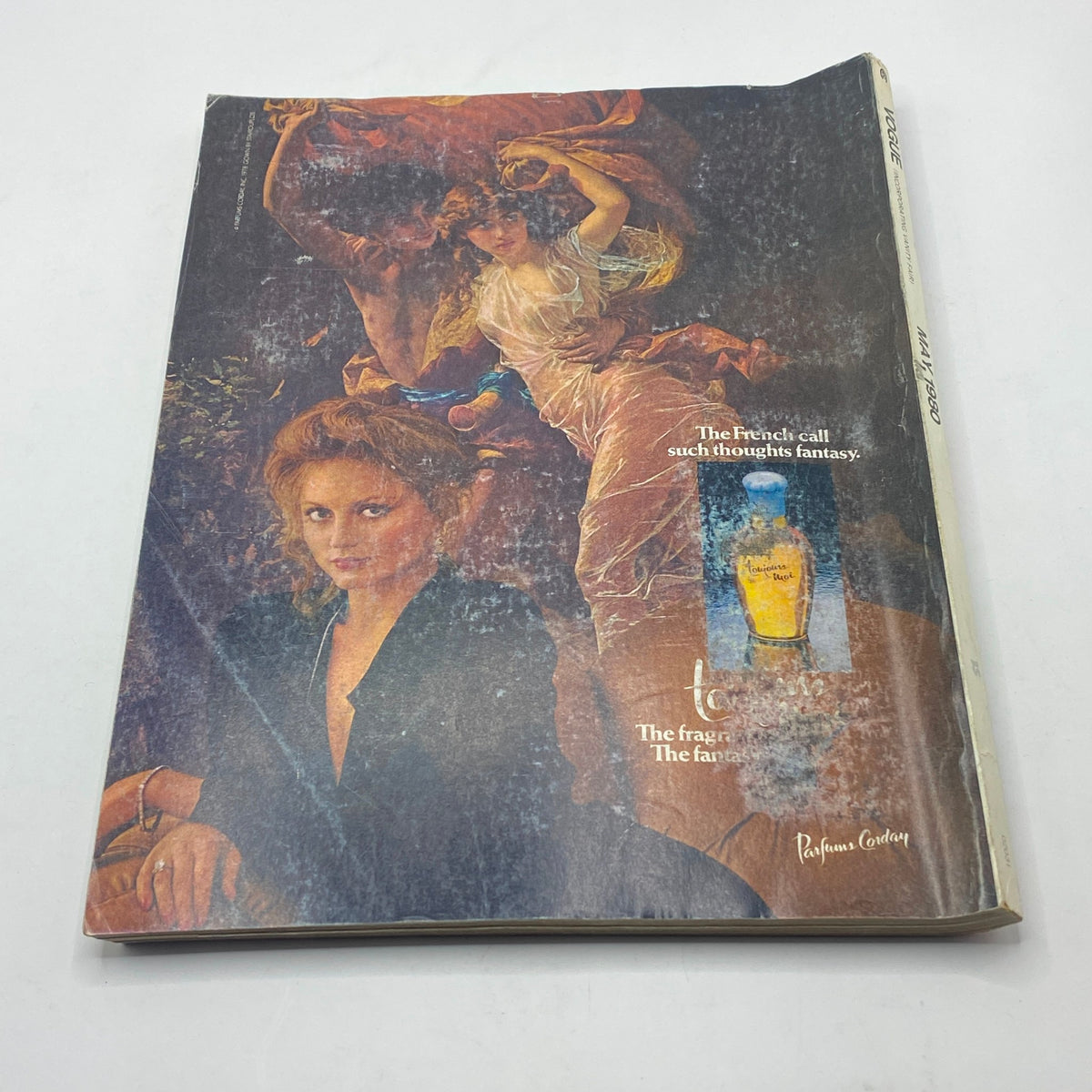 The cover of Vogue Magazine May 1980 displaying a captivating advertisement for a fantasy-themed fragrance, featuring an illustration of classical art with a model showcasing sophisticated beauty.