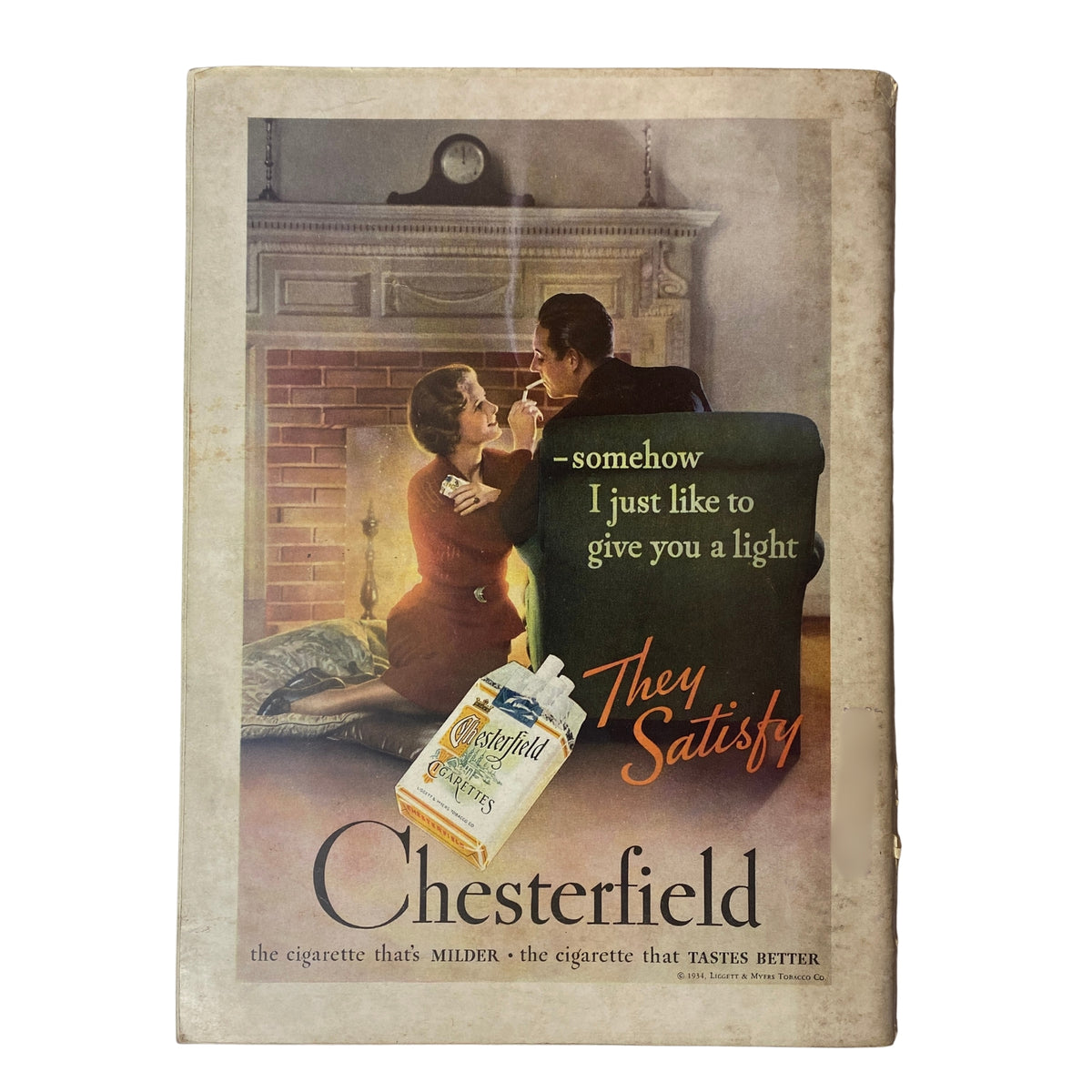 Chesterfield cigarette advertisement from the 1930s, featuring a romantic couple in front of a fireplace with the tagline 'They Satisfy', emphasizing the brand's appeal.