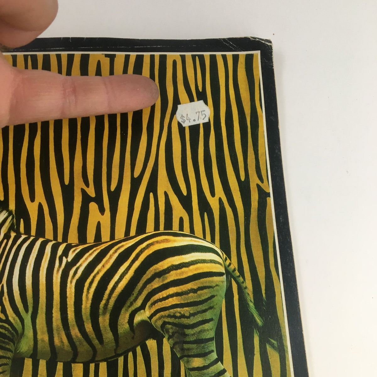 Close-up of the cover of Photography Magazine December 1987, showing the price sticker of $4.75 for the issue featuring 'Animals Earning Their Stripes'.
