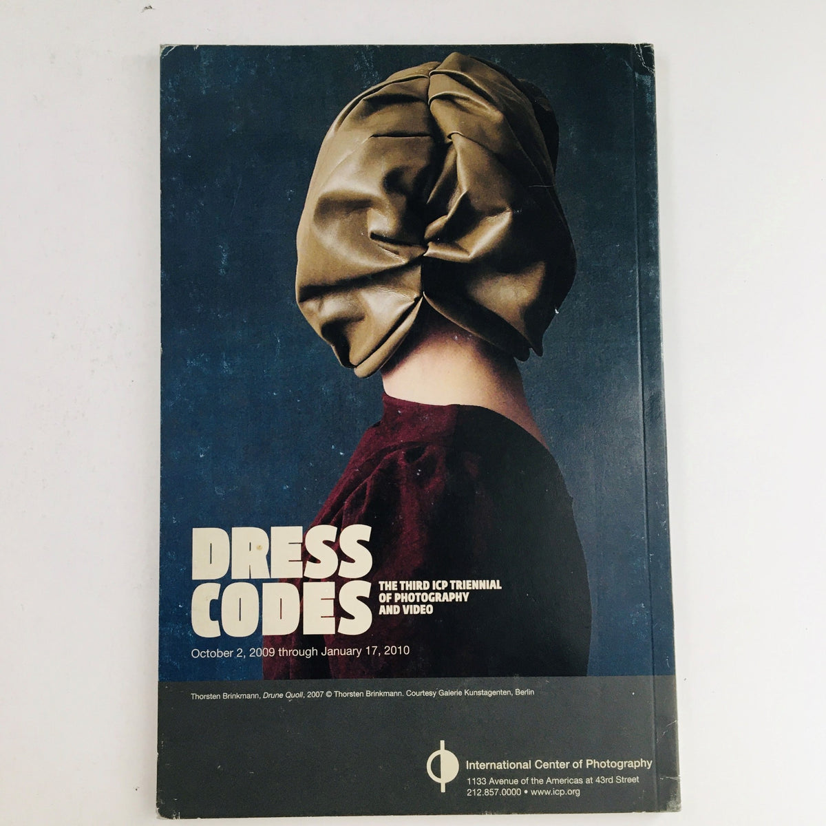 Cover of the International Center of Photography's 2009 exhibition catalog titled 'Dress Codes,' showcasing a unique artistic image.