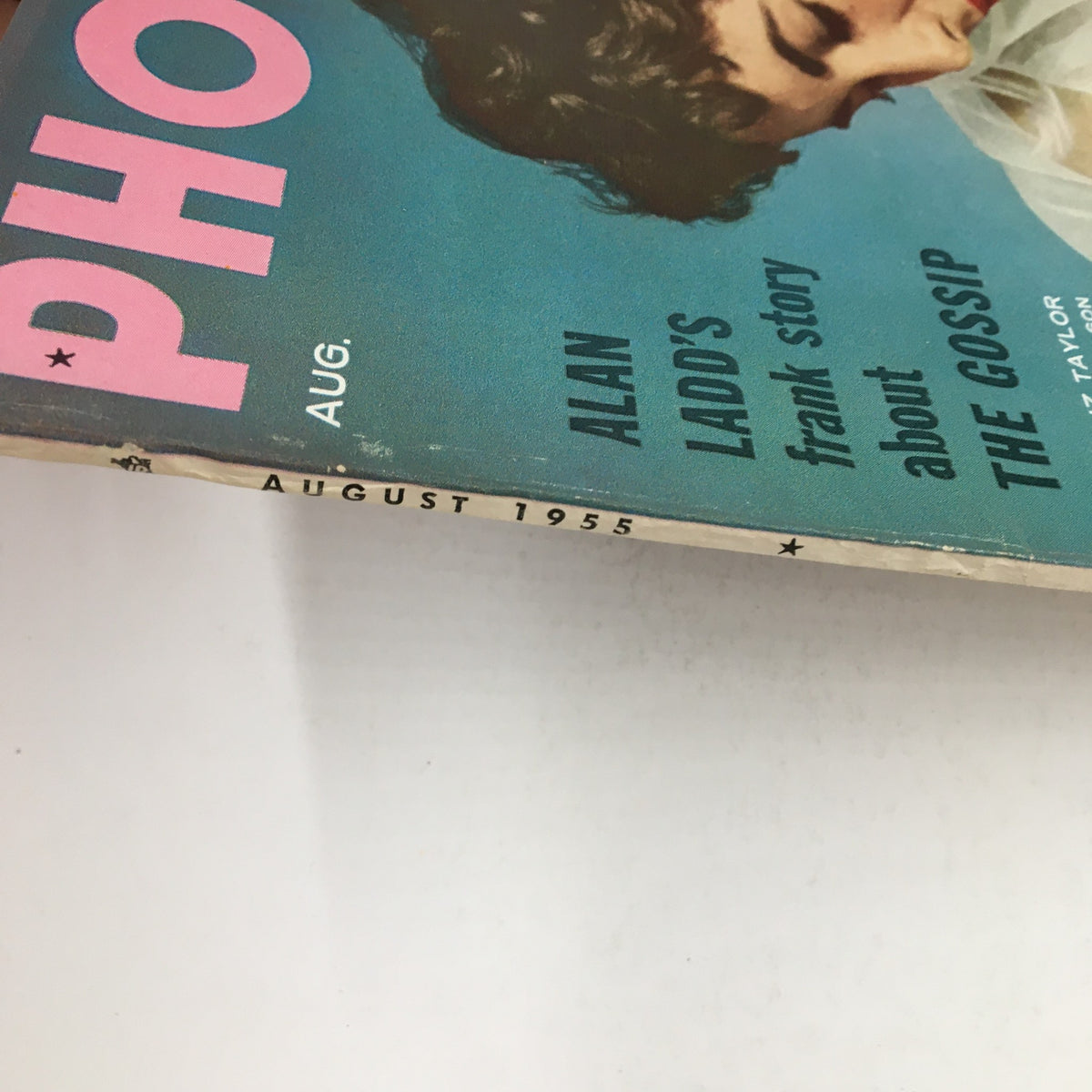 Close-up view of the edge of Photoplay Magazine August 1955, showcasing the magazine title, month and year, and details about featured content including Elizabeth Taylor.