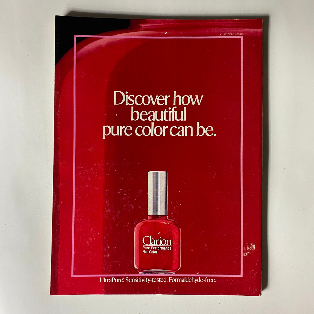 Vintage Vogue Magazine January 1988 advertisement for Clarion Pure Performance Nail Color featuring a vibrant red nail polish bottle against a bold red backdrop, highlighting beauty and color trends of the era.