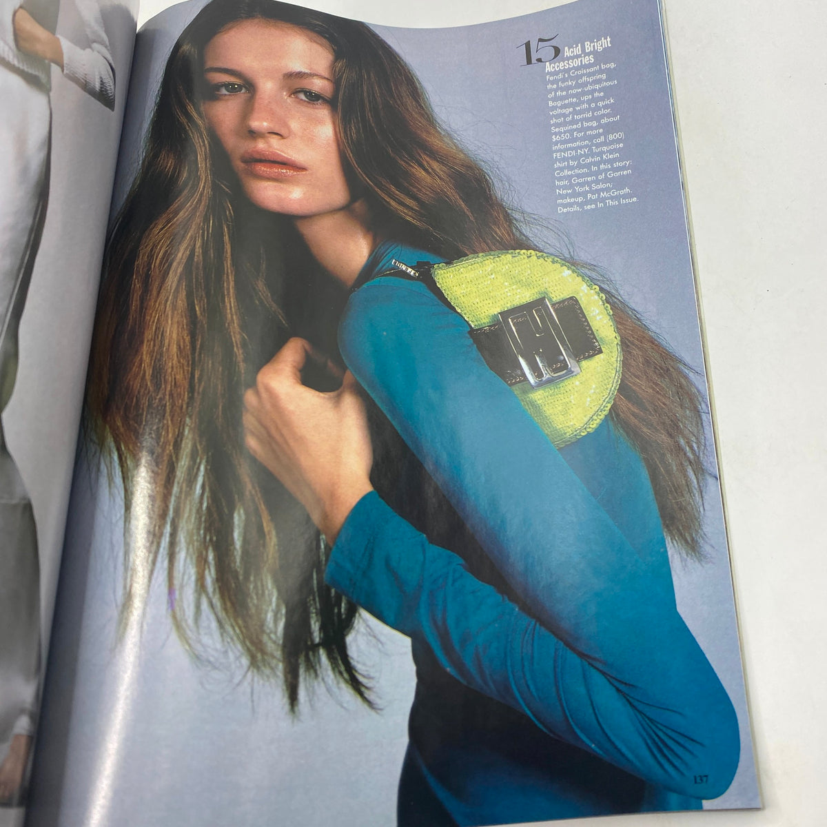 Vogue Magazine January 1999, highlighting a model with long hair wearing a blue outfit and a yellow accessory, emphasizing late 90s fashion trends.