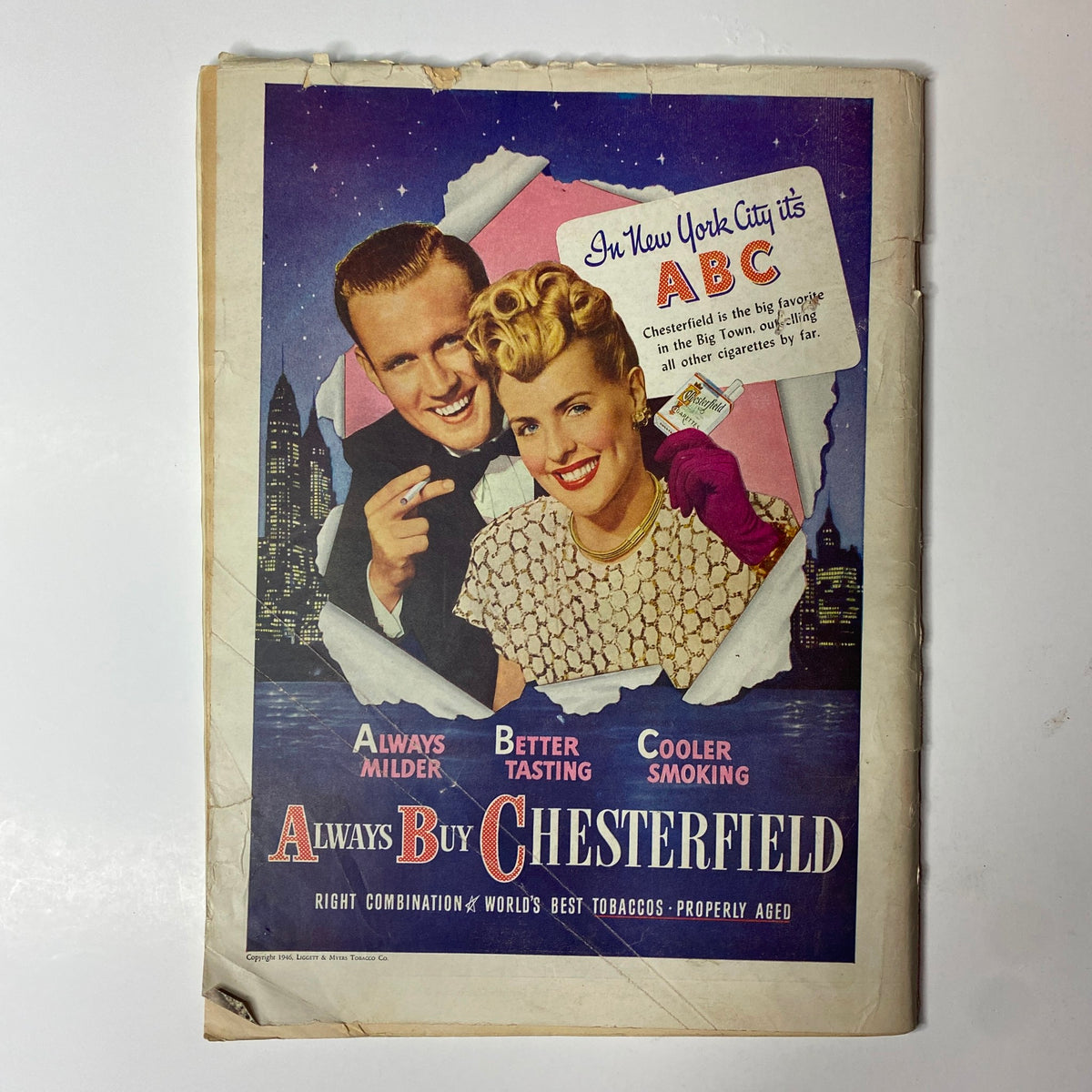 Vintage advertisement for Chesterfield cigarettes in an issue of Time Magazine, showcasing a smiling couple against a city skyline, promoting Chesterfield as the preferred cigarette brand.
