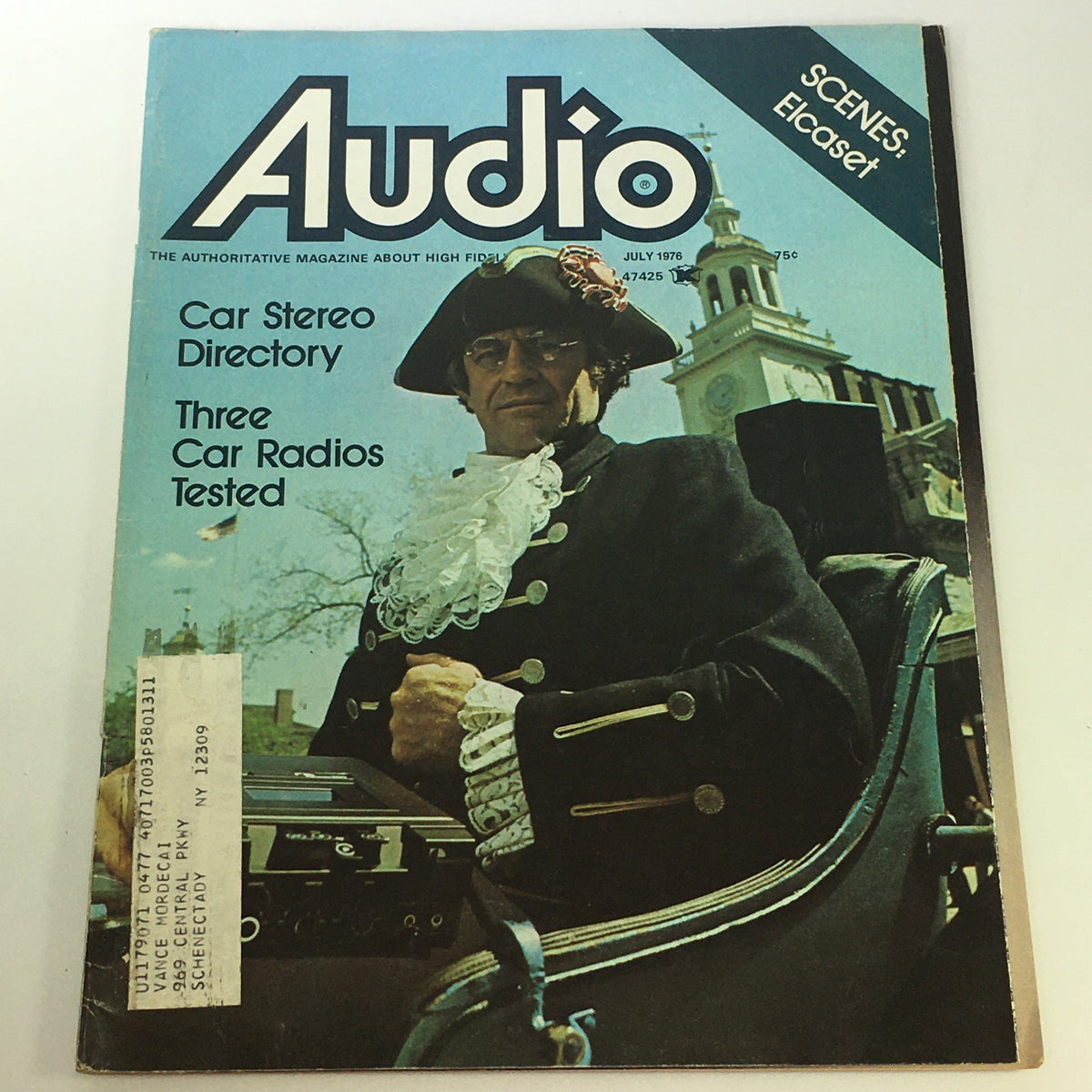 Cover of the VTG Audio & Music Magazine July 1976 featuring a Car Stereo Directory, with the headline 'Scenes: Elcaset'. The cover shows a man in historical attire, along with car radio testing references, reflecting the audio culture of the mid-1970s.