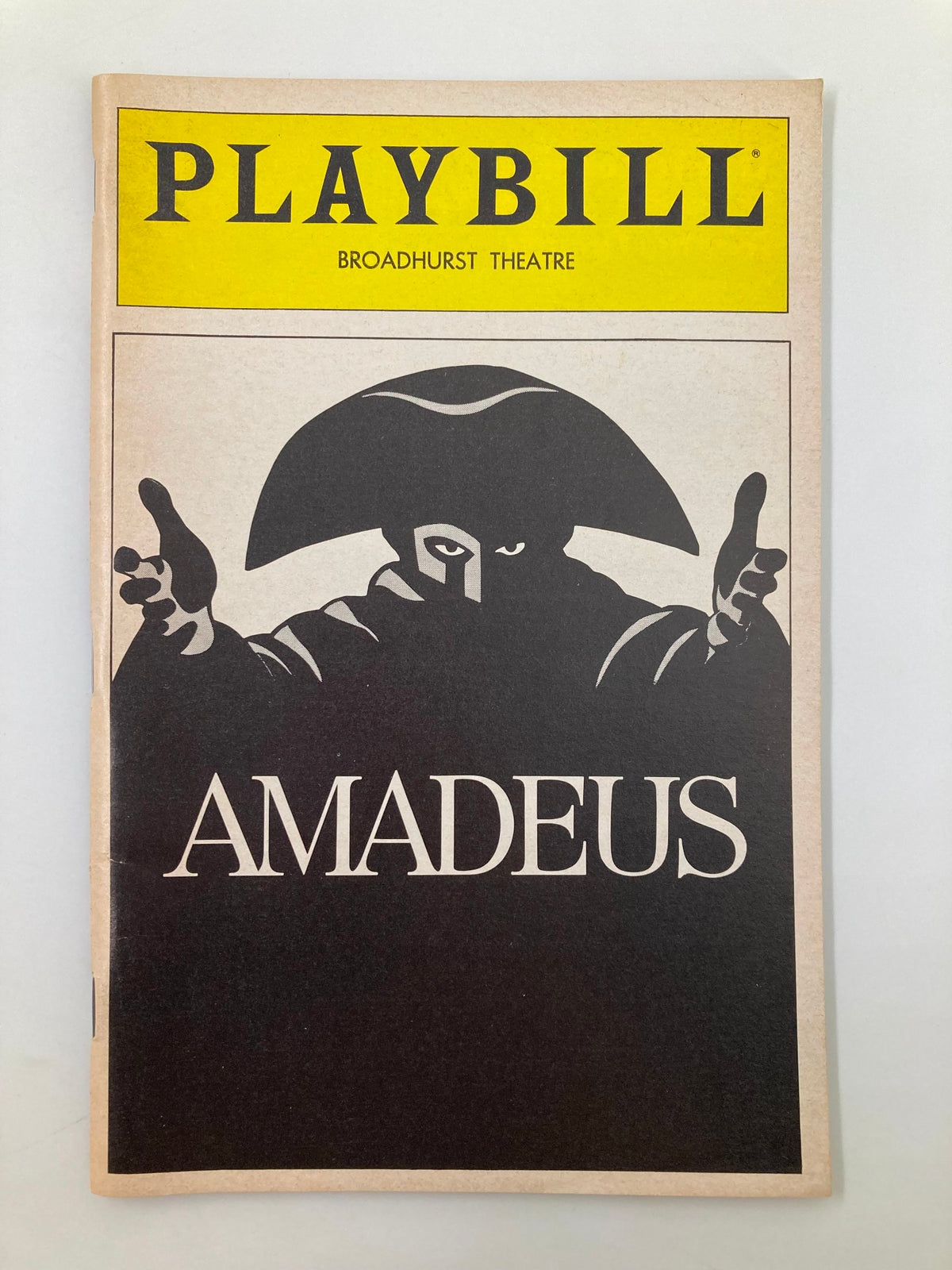 1983 Playbill from Broadhurst Theatre featuring the title 'Amadeus' with artistic rendering of a character in a hat, in very good condition.