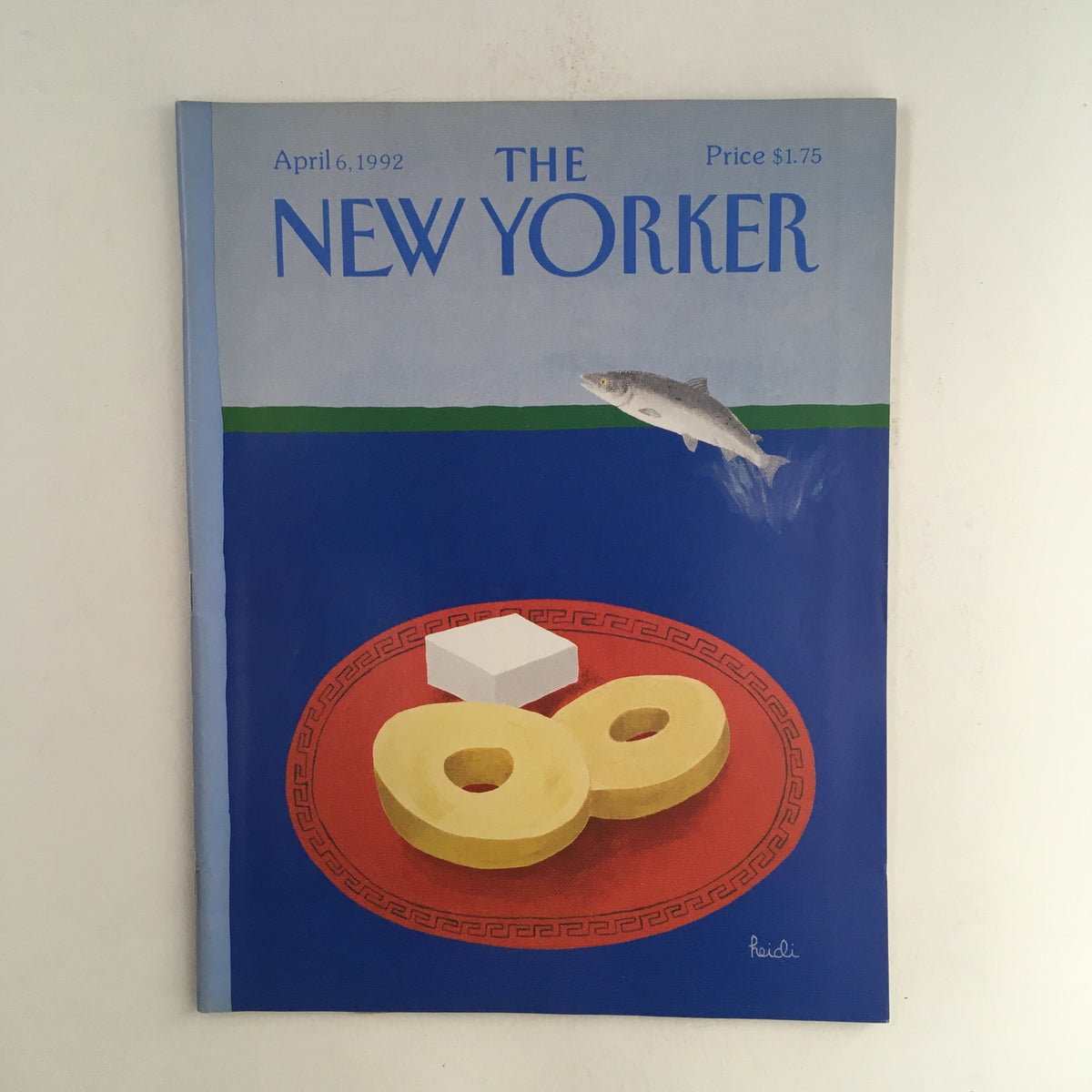 Cover of The New Yorker April 6, 1992, featuring an artistic design by Heidi Goennel, showcasing a plate with two circular pastries, a piece of butter, and a fish swimming above, in a vibrant blue and green color scheme.