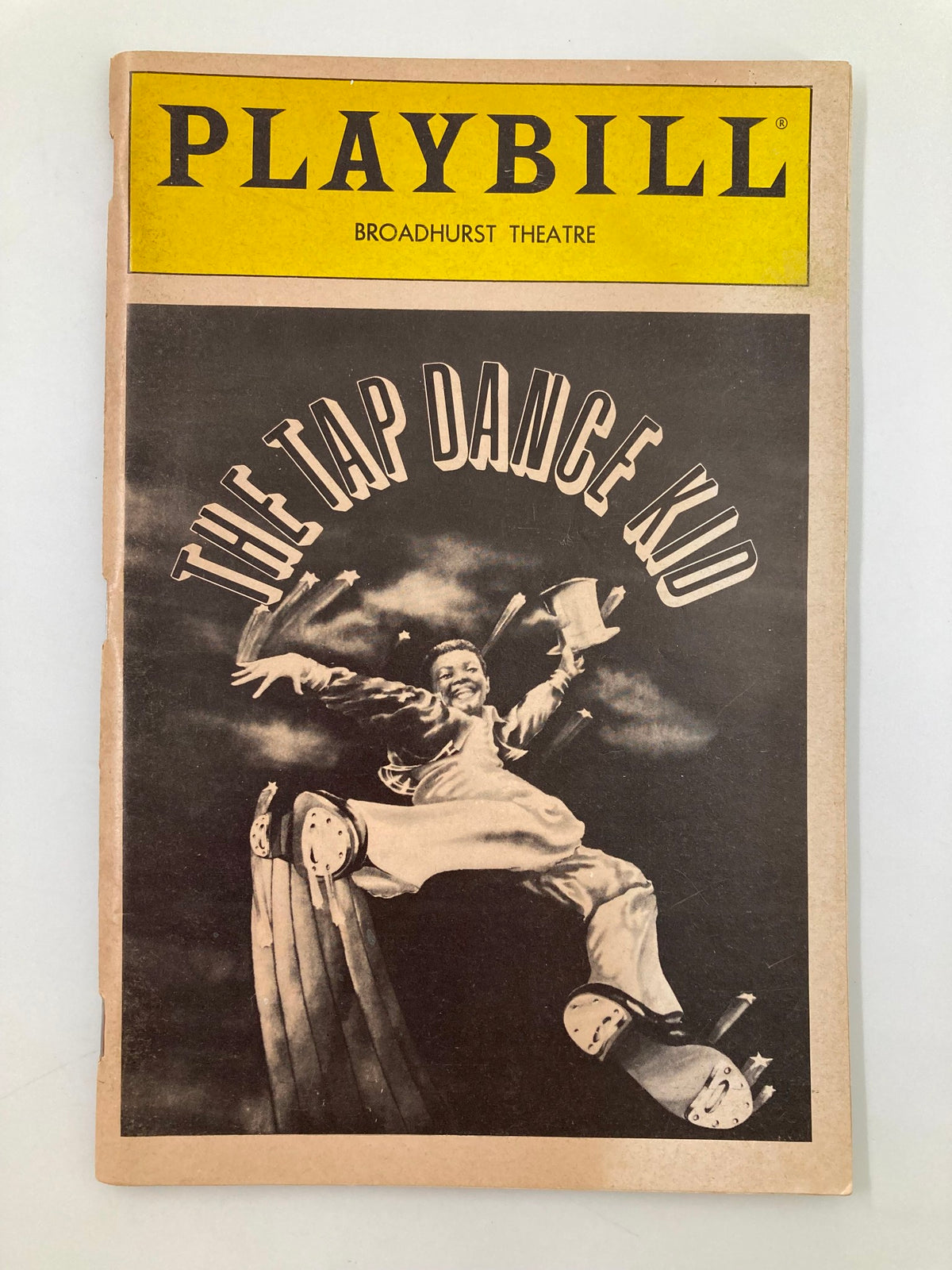 1983 Playbill for The Tap Dance Kid at the Broadhurst Theater featuring Hinton Battle with a dynamic cover image showcasing a joyful dancer.