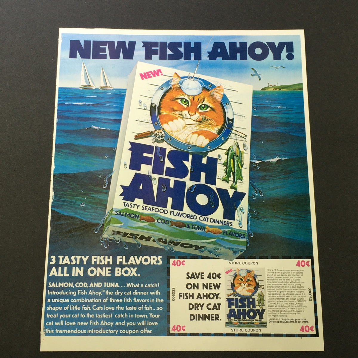 VTG Retro 1980 Fish Ahoy Tasty Seafood Flavored Cat Dinners Print Ad Coupon featuring a cat, sailing boats in the background, and an introduction to the product. The ad emphasizes three fish flavors in one box and a coupon savings offer.