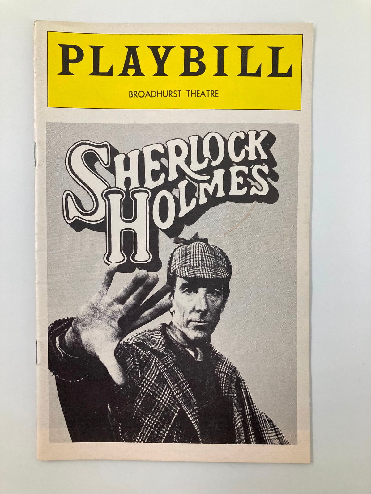 1975 Playbill Broadhurst Theatre Sherlock Holmes cover featuring an actor in period costume, showcasing a dramatic gesture and vintage design.