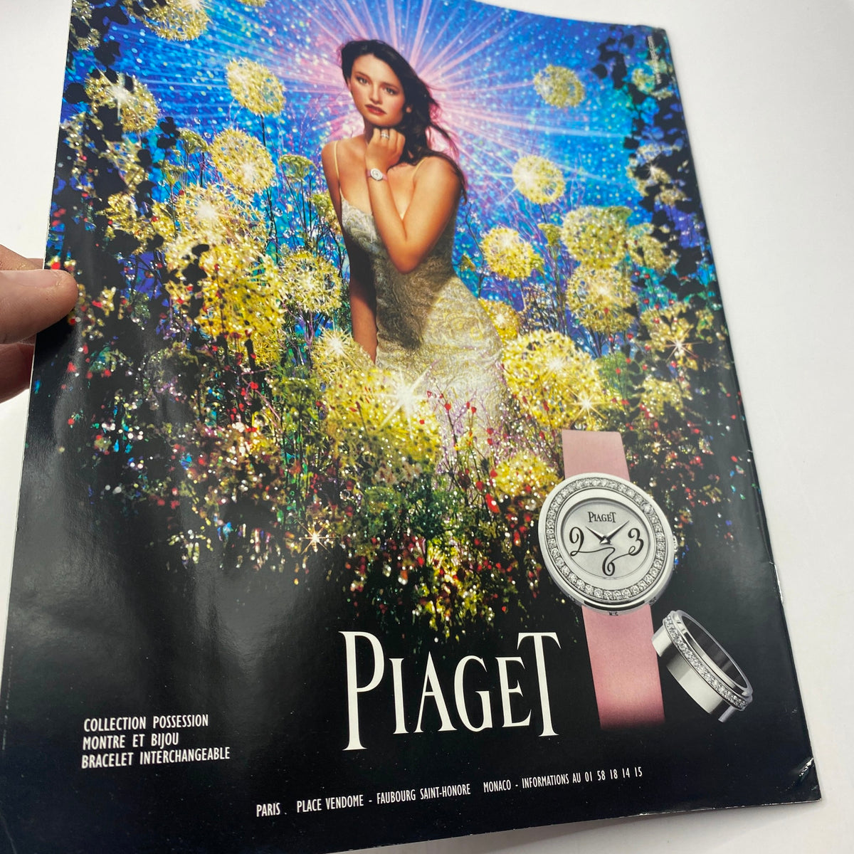 Vogue Paris Supplement December 2005 displaying Piaget jewelry and a model in a sparkling dress, surrounded by colorful flowers, highlighting elegance and fashion.