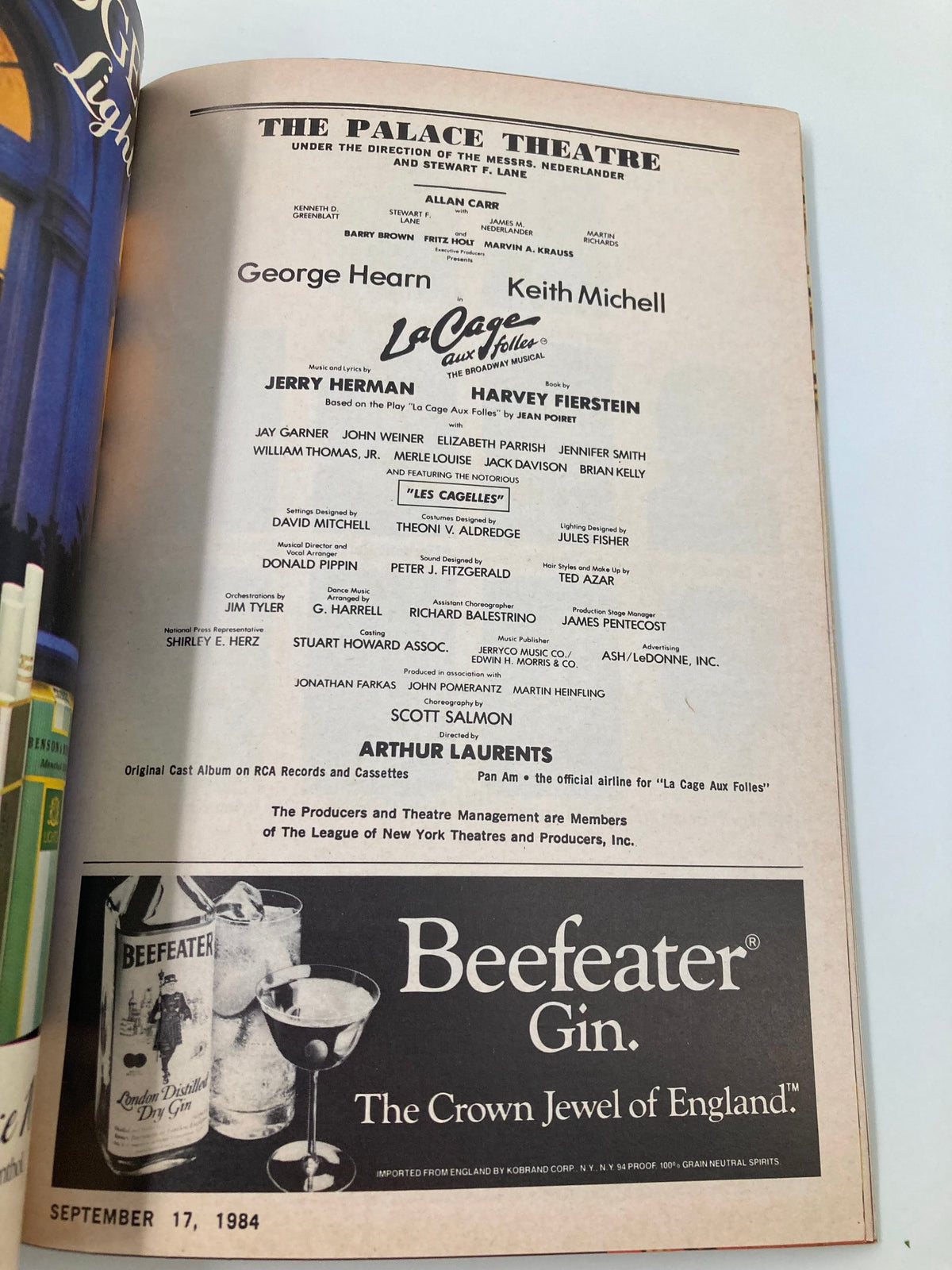 Highlighted section of a 1984 Playbill from The Palace Theatre presenting La Cage Aux Folles starring George Hearn and Keith Michell. This image displays credits, cast information, and advertisements relevant to the performance.