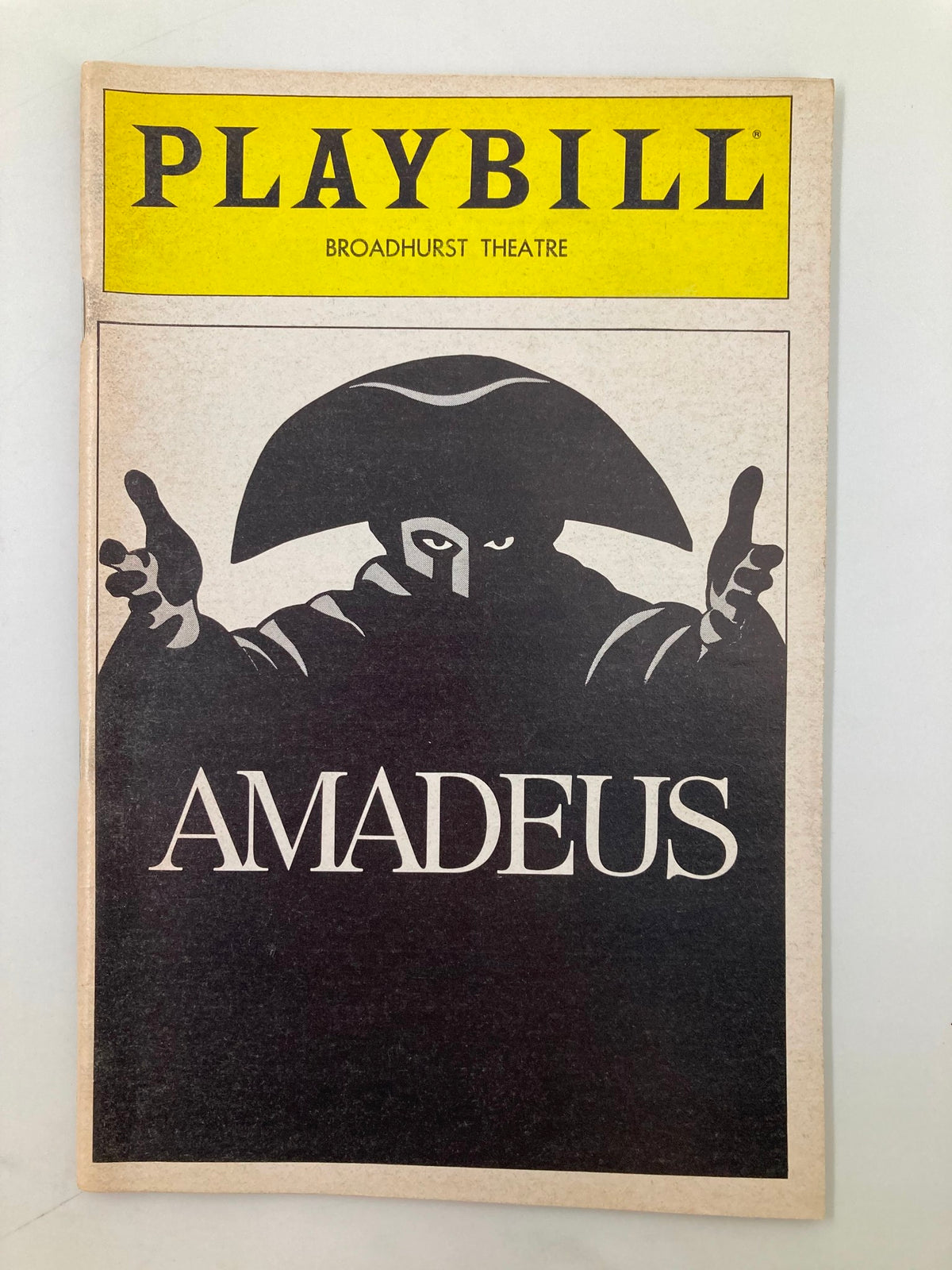 1983 Playbill for Amadeus at Broadhurst Theater featuring a dramatic cover design with a character in a black cape and hat.