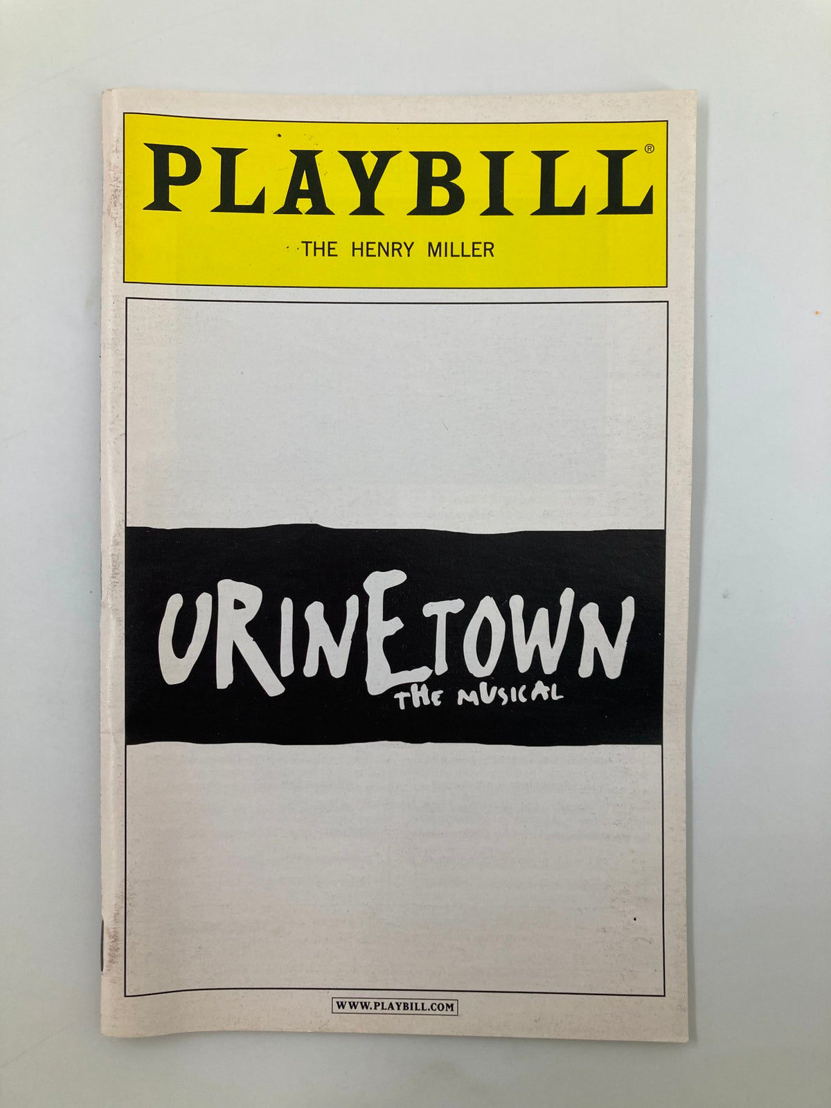 2002 Playbill for Urinetown at The Henry Miller Theatre featuring iconic title design.