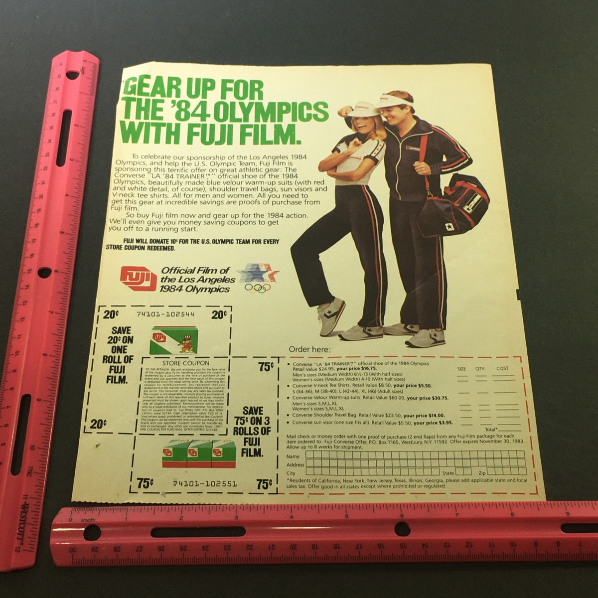 Overview of the VTG 1983 - Fuji Official Film of the Los Angeles 1984 Olympics Store Ad Coupon, displaying an Olympic-themed merchandise order form, including images of athletes wearing Fuji Film-branded apparel.