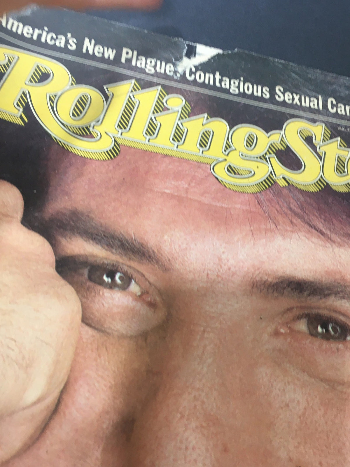 Close-up view of the Vintage Rolling Stone Magazine February 3 1983 cover highlighting Dustin Hoffman, emphasizing his eyes and the magazine's title with some wear and tear typical of a collector's item.