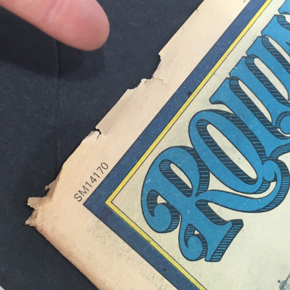 Close-up of the edge of the Rolling Stone Magazine from July 29, 1976, showing minor wear and a tear, highlighting its vintage condition and authenticity as a collectible item featuring Jack Ford and Alfred Hitchcock.