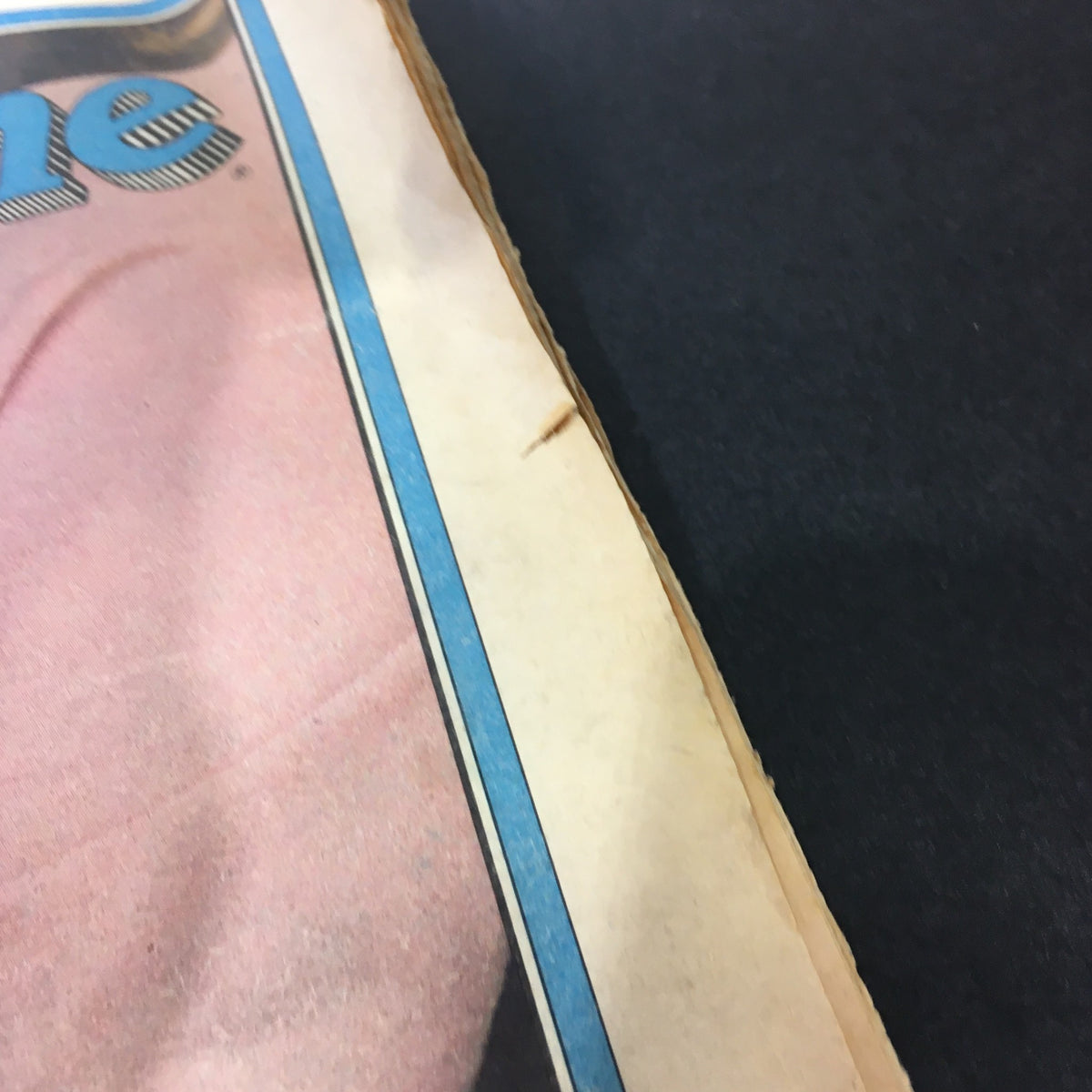 Detail of the edge of the vintage Rolling Stone magazine from November 27, 1980 featuring Jill Clayburgh and Michael Douglas. The image shows wear and tear, with visible creases and a small rip, indicating its collectible nature.