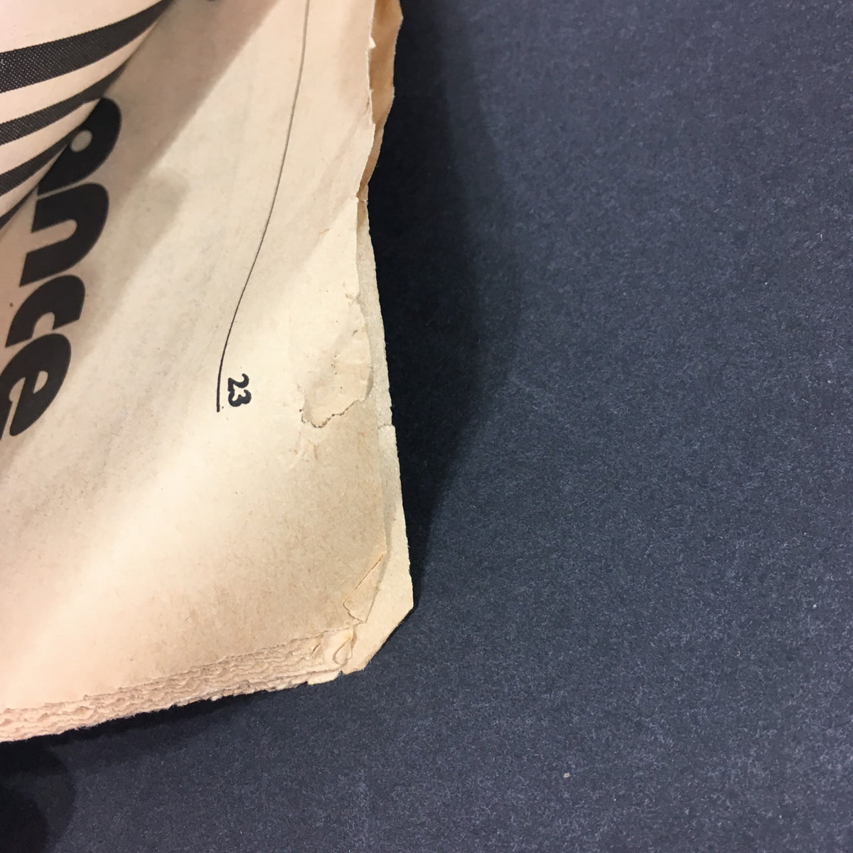 Close-up of the edge of the VTG Rolling Stone Magazine August 26, 1976, showing minor wear and tear, highlighting its vintage condition.