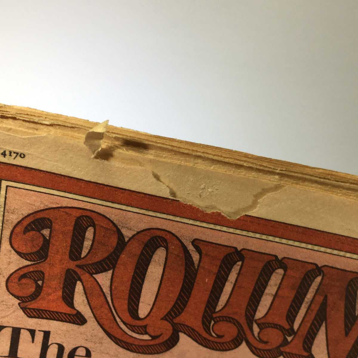 Close-up of the top edge of Rolling Stone Magazine from November 3, 1977, highlighting a tear and wear, preserving the vintage charm of this collectible issue.