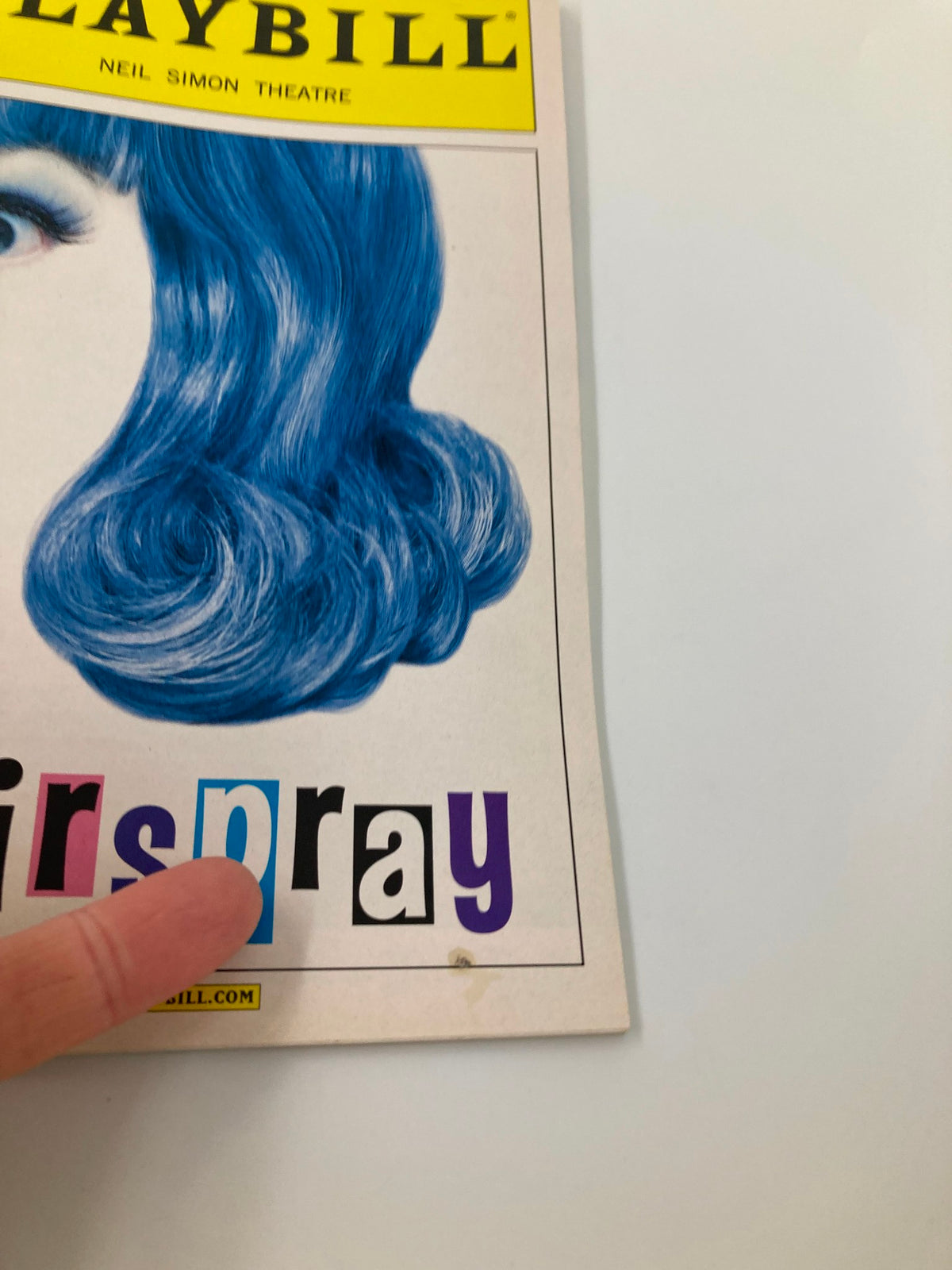 Close-up of the 2002 Hairspray Playbill showing details of the title with blue hair character on the cover.